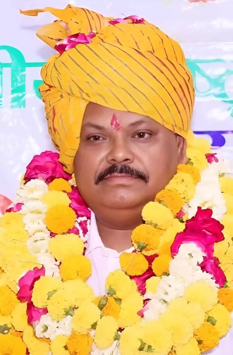 तस्वीर में माथे पर तिलक, पीले रंग की राजस्थानी पगड़ी और गले में फूलों की माला पहने एक व्यक्ति नजर आ रहे हैं। तस्वीर में माथे पर तिलक, पीले रंग की राजस्थानी पगड़ी और गले में फूलों की माला पहने एक व्यक्ति नजर आ रहे हैं।