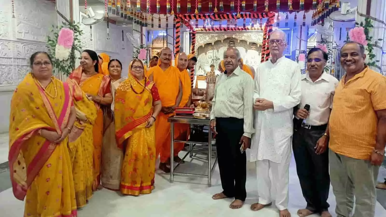 तस्वीर में बाएं से दाएं पीली और गुलाबी साड़ी पहने महिलाएं, भगवा वस्त्र पहने लोग तथा दाईं ओर खड़े पुरुष नजर आ रहे हैं। तस्वीर में बाएं से दाएं पीली और गुलाबी साड़ी पहने महिलाएं, भगवा वस्त्र पहने लोग तथा दाईं ओर खड़े पुरुष नजर आ रहे हैं।
