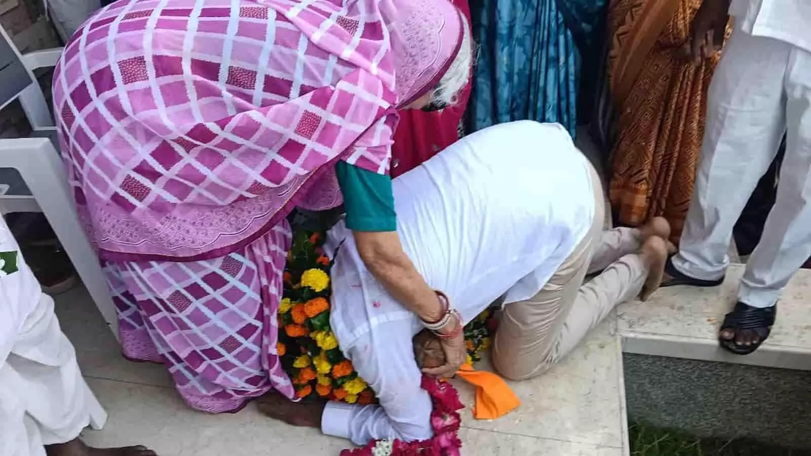 तस्वीर में सफेद शर्ट पहने नरेश जैन फूलों की माला पहनकर बुजुर्ग महिला के सामने झुककर प्रणाम कर रहे हैं। तस्वीर में सफेद शर्ट पहने नरेश जैन फूलों की माला पहनकर बुजुर्ग महिला के सामने झुककर प्रणाम कर रहे हैं।