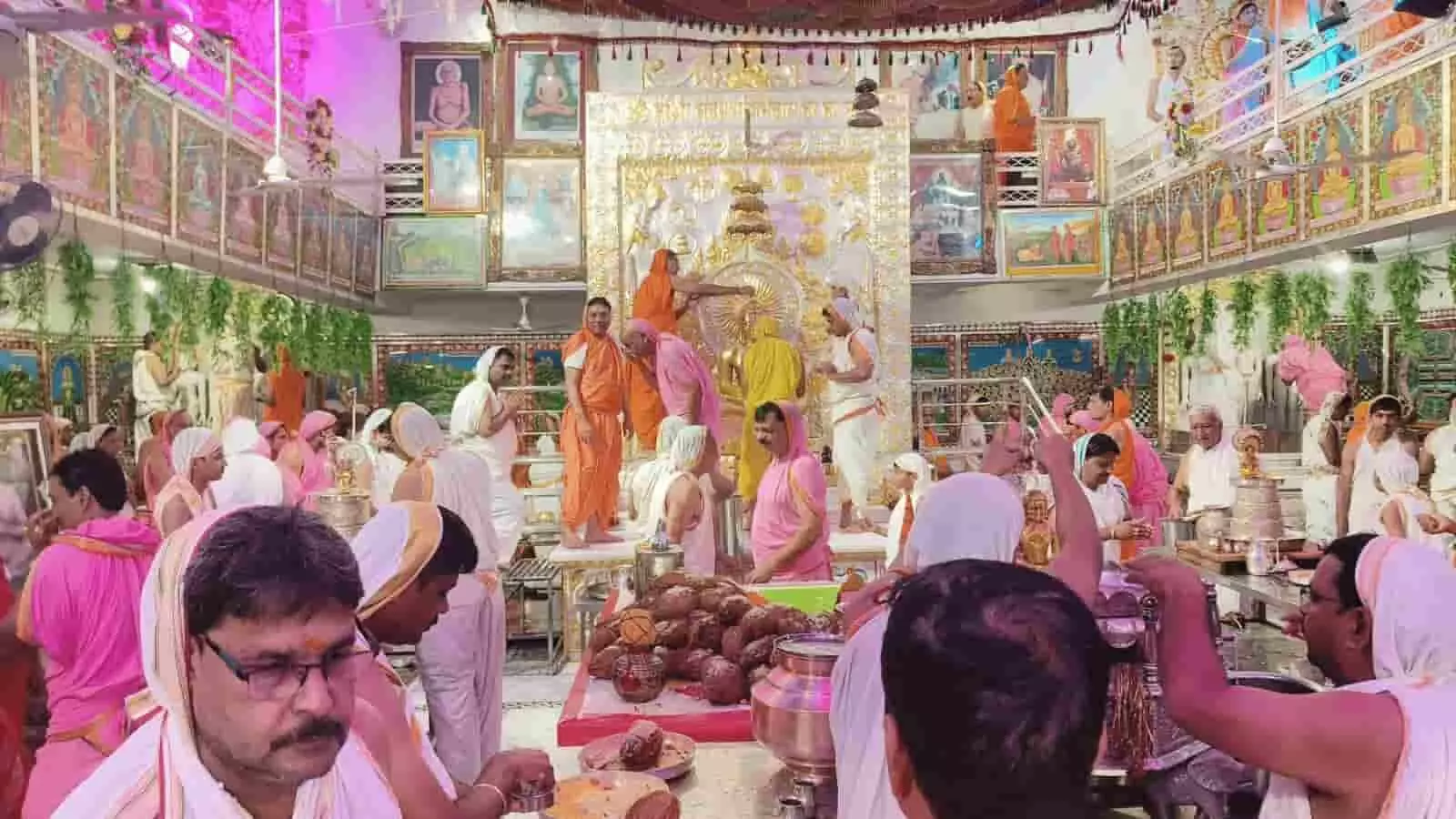 तस्वीर में मंदिर के प्रांगण में पारंपरिक कपड़ों में बैठे और खड़े हुए श्रद्धालु तथा अनुष्ठान करते लोग नजर आ रहे हैं। तस्वीर में मंदिर के प्रांगण में पारंपरिक कपड़ों में बैठे और खड़े हुए श्रद्धालु तथा अनुष्ठान करते लोग नजर आ रहे हैं।