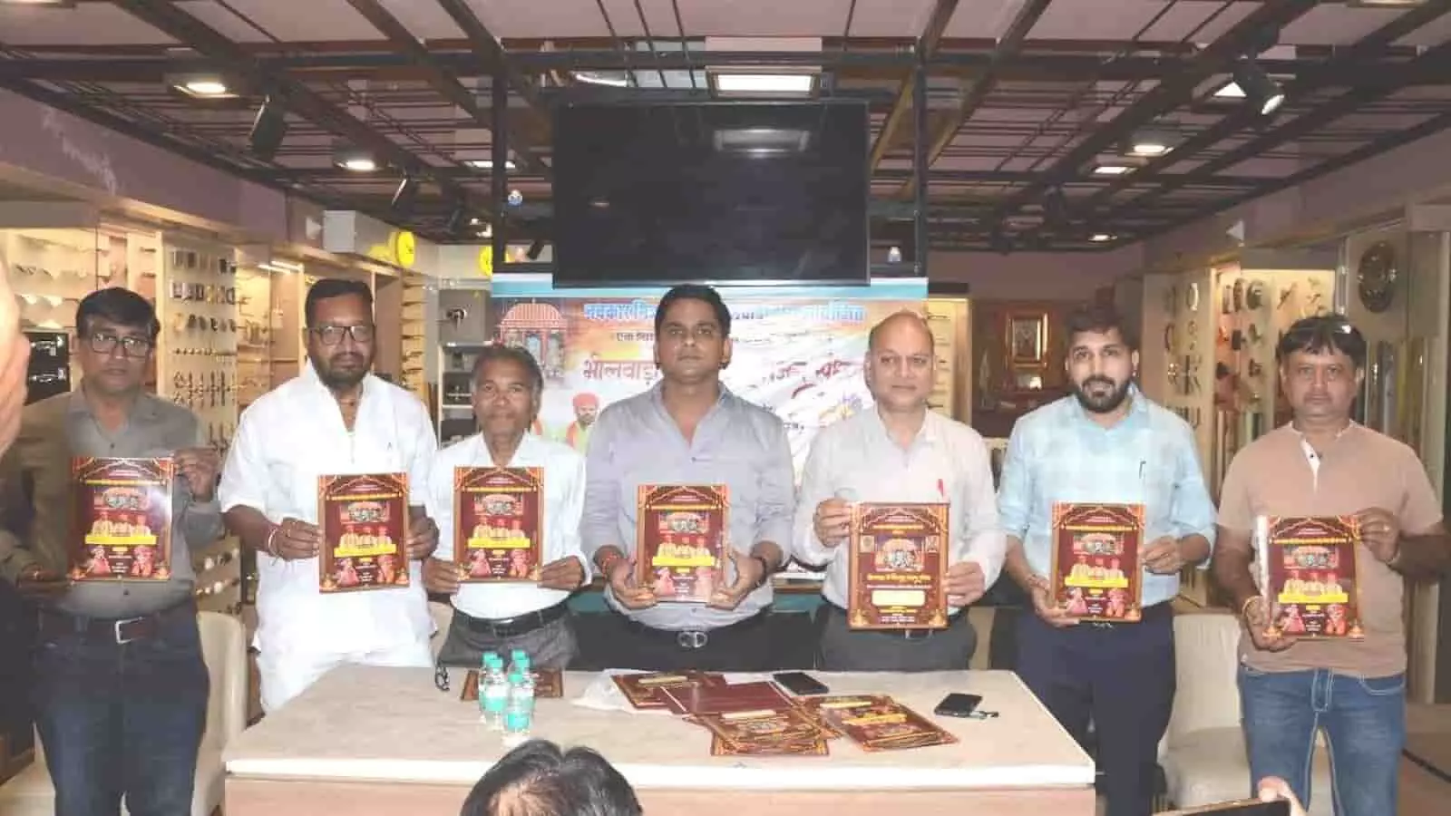 तस्वीर में दिख रहे सात लोग एक मेज के पीछे खड़े होकर धार्मिक पोस्टर प्रदर्शित कर रहे हैं। तस्वीर में दिख रहे सात लोग एक मेज के पीछे खड़े होकर धार्मिक पोस्टर प्रदर्शित कर रहे हैं।