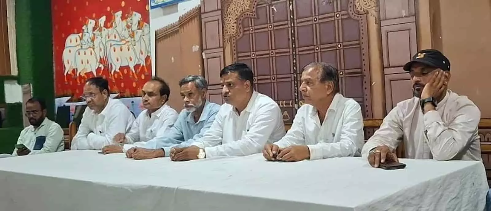 कपासन में एक प्रेस कॉन्फ्रेंस के दौरान मेज के पीछे एक कतार में बैठे कांग्रेस पदाधिकारी और कार्यकर्ता। कपासन में एक प्रेस कॉन्फ्रेंस के दौरान मेज के पीछे एक कतार में बैठे कांग्रेस पदाधिकारी और कार्यकर्ता।