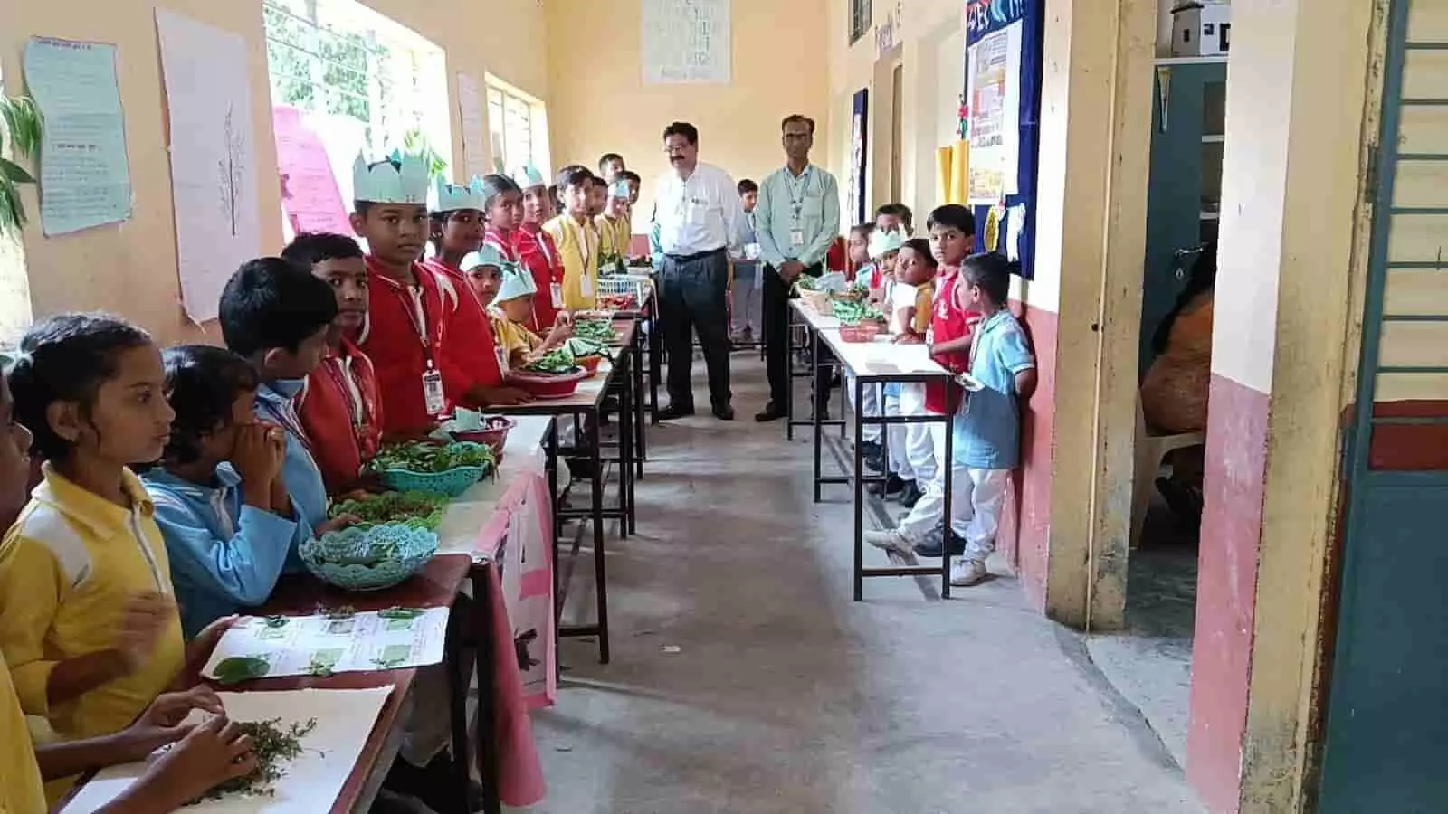 तस्वीर में स्कूल के गलियारे में सजे स्टॉल के पास बच्चे और शिक्षक रानभाजी प्रदर्शन का अवलोकन करते हुए खड़े हैं。 तस्वीर में स्कूल के गलियारे में सजे स्टॉल के पास बच्चे और शिक्षक रानभाजी प्रदर्शन का अवलोकन करते हुए खड़े हैं。