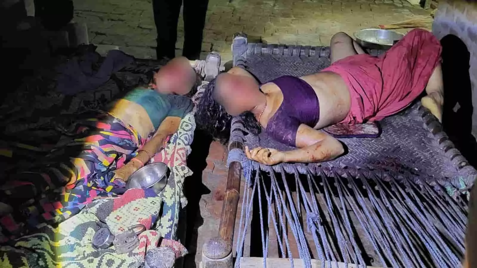 तस्वीर में एक कमरे के अंदर चारपाई पर दो महिलाओं के शव रखे हुए हैं और उनके चेहरे सुरक्षित रूप से अस्पष्ट किए गए हैं। तस्वीर में एक कमरे के अंदर चारपाई पर दो महिलाओं के शव रखे हुए हैं और उनके चेहरे सुरक्षित रूप से अस्पष्ट किए गए हैं।
