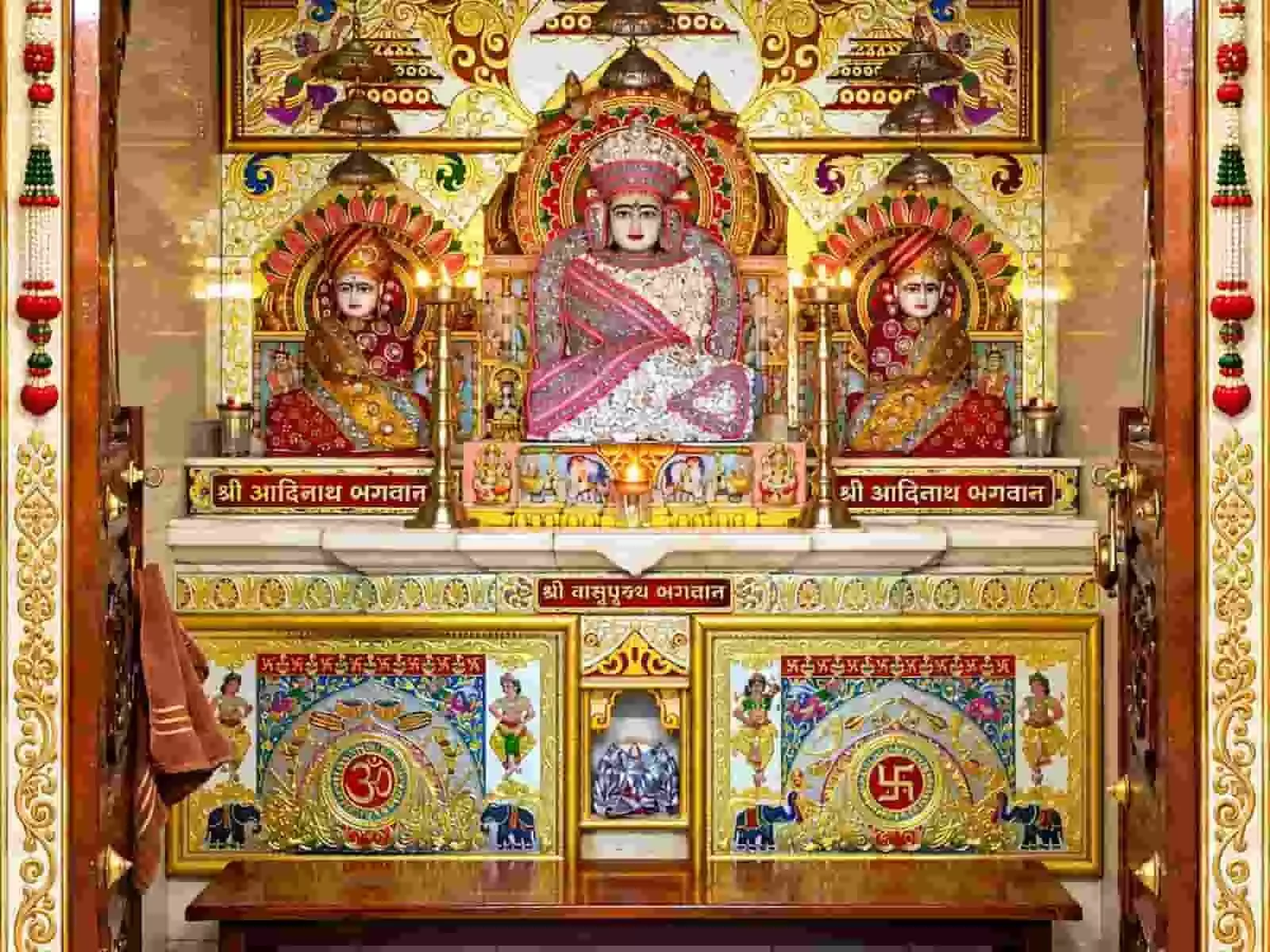 तस्वीर में दिख रही जैन मंदिर की वेदी पर भगवान वासुपूज्य और आदिनाथ की प्रतिमाएं सुंदर वस्त्रों से अलंकृत हैं। तस्वीर में दिख रही जैन मंदिर की वेदी पर भगवान वासुपूज्य और आदिनाथ की प्रतिमाएं सुंदर वस्त्रों से अलंकृत हैं।