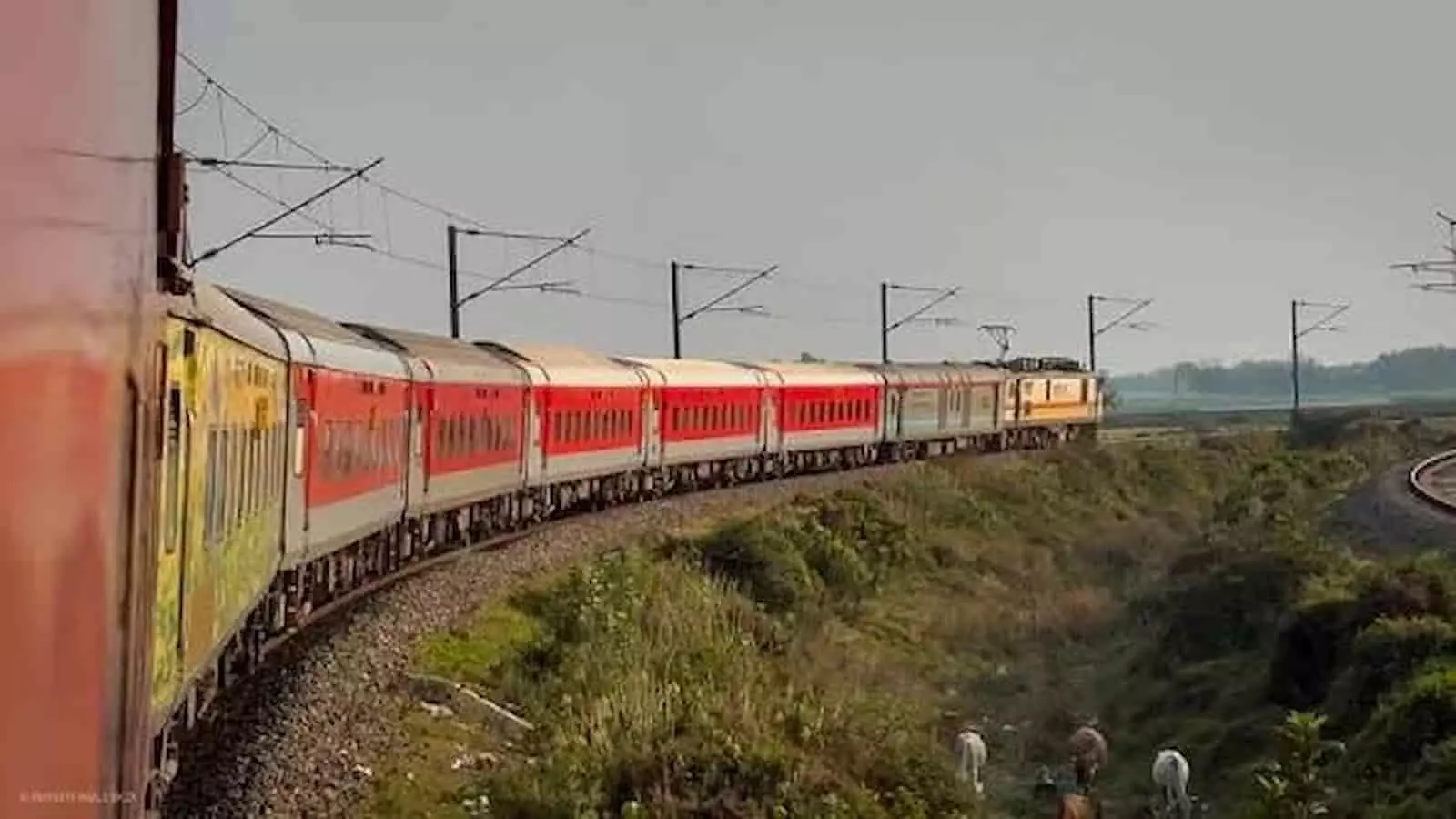 तस्वीर में पटरियों पर चलती हुई एक एक्सप्रेस ट्रेन और आसपास हरियाली दिखाई दे रही है। तस्वीर में पटरियों पर चलती हुई एक एक्सप्रेस ट्रेन और आसपास हरियाली दिखाई दे रही है।