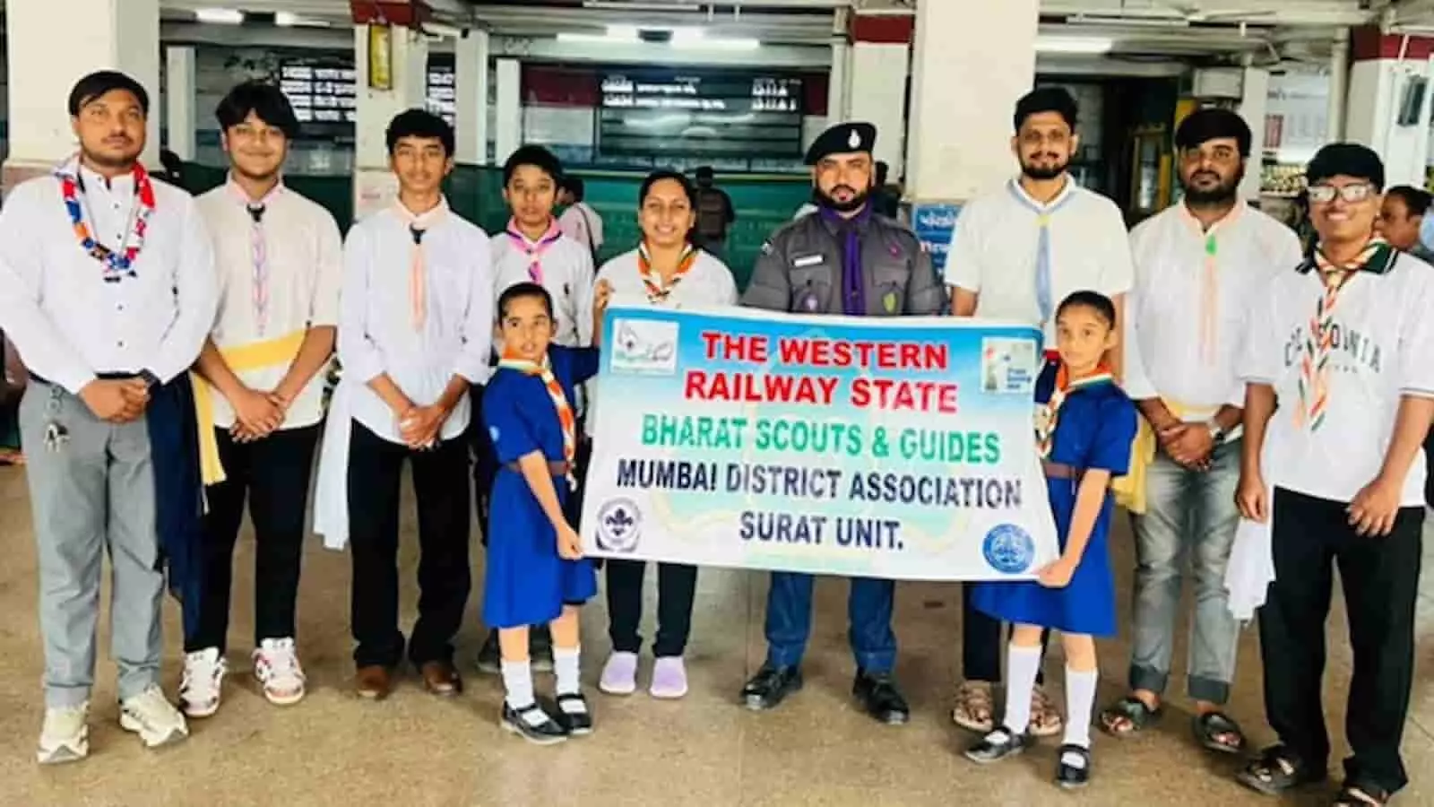 तस्वीर में स्काउट्स एंड गाइड्स के सदस्य रेलवे स्टेशन पर बैनर पकड़े हुए खड़े हैं। तस्वीर में स्काउट्स एंड गाइड्स के सदस्य रेलवे स्टेशन पर बैनर पकड़े हुए खड़े हैं।