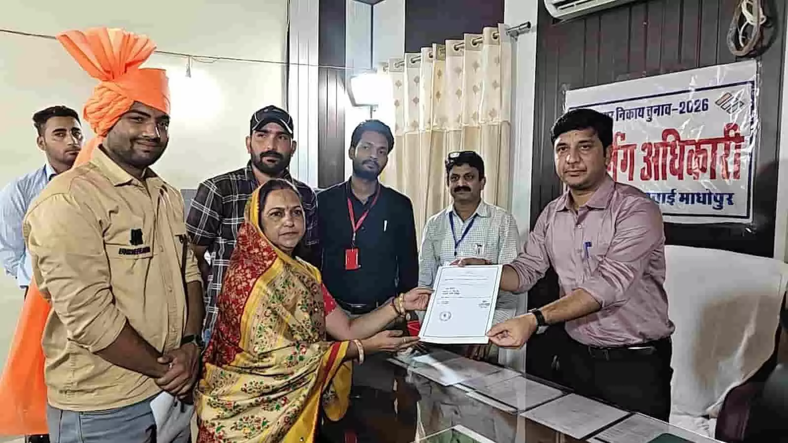 तस्वीर में बाएँ से दाएँ खड़े समर्थकों के साथ महिला प्रत्याशी अधिकारी से प्रमाण पत्र ले रही हैं। तस्वीर में बाएँ से दाएँ खड़े समर्थकों के साथ महिला प्रत्याशी अधिकारी से प्रमाण पत्र ले रही हैं।