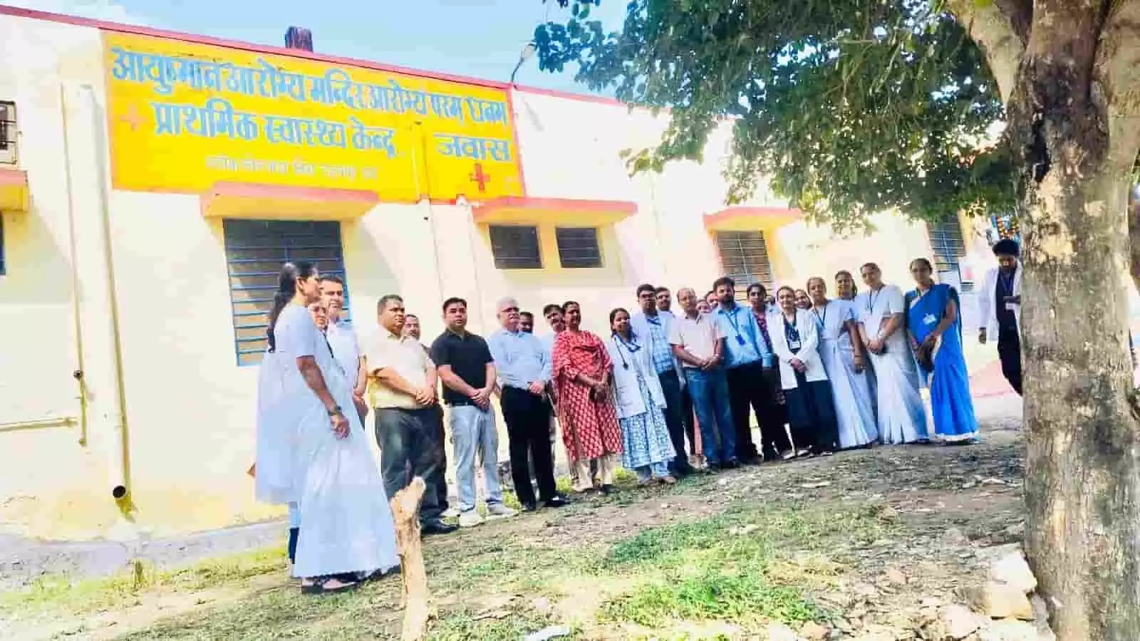तस्वीर में स्वास्थ्य केंद्र की इमारत के बाहर चिकित्सा अधिकारी, कर्मचारी और ग्रामीण समूह में खड़े दिखाई दे रहे हैं。 तस्वीर में स्वास्थ्य केंद्र की इमारत के बाहर चिकित्सा अधिकारी, कर्मचारी और ग्रामीण समूह में खड़े दिखाई दे रहे हैं。