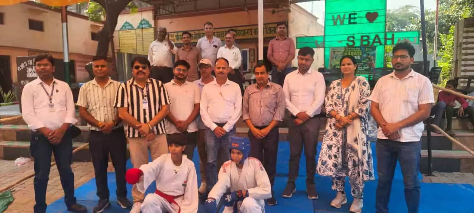 तस्वीर में दिख रही जगह स्कूल परिसर है, जहां अतिथि और कराटे पोशाक पहने खिलाड़ी उपस्थित हैं। तस्वीर में दिख रही जगह स्कूल परिसर है, जहां अतिथि और कराटे पोशाक पहने खिलाड़ी उपस्थित हैं।