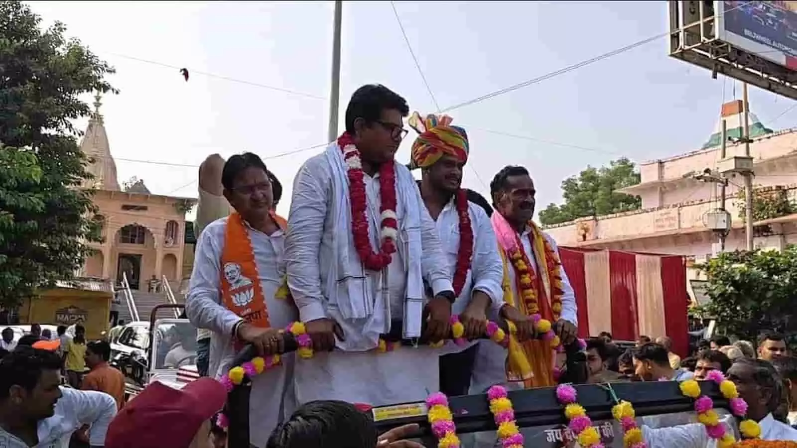 तस्वीर में एक खुली गाड़ी में माला पहने नेता और जनप्रतिनिधि खड़े होकर जुलूस निकाल रहे हैं और नीचे भीड़ मौजूद है। तस्वीर में एक खुली गाड़ी में माला पहने नेता और जनप्रतिनिधि खड़े होकर जुलूस निकाल रहे हैं और नीचे भीड़ मौजूद है।