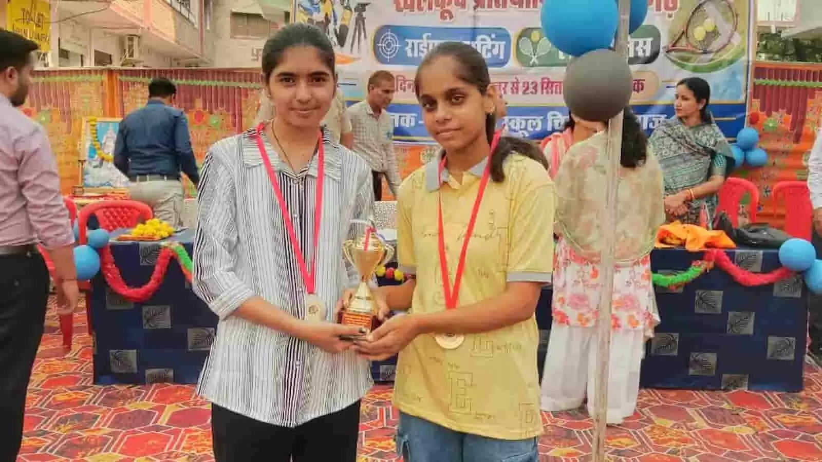 तस्वीर में दिख रही दो छात्राएं गले में पदक पहनकर संयुक्त रूप से ट्रॉफी थामे खड़ी हैं। तस्वीर में दिख रही दो छात्राएं गले में पदक पहनकर संयुक्त रूप से ट्रॉफी थामे खड़ी हैं।