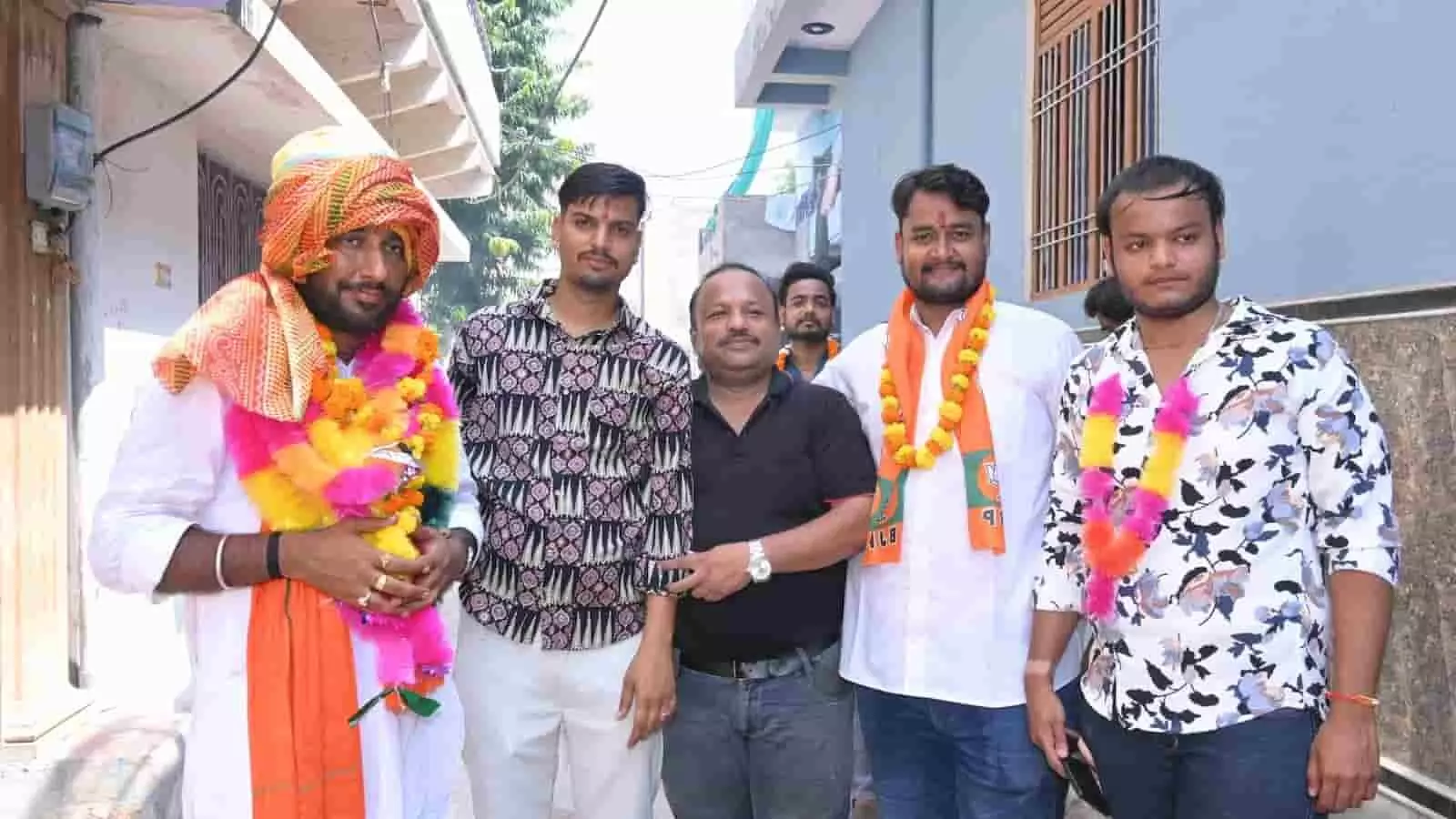 तस्वीर में बाएं से दाएं, साफा और माला पहने विजेंद्र गुर्जर, उनके साथ खड़े तीन अन्य समर्थक और एक व्यक्ति गली में खड़े हैं。 तस्वीर में बाएं से दाएं, साफा और माला पहने विजेंद्र गुर्जर, उनके साथ खड़े तीन अन्य समर्थक और एक व्यक्ति गली में खड़े हैं。