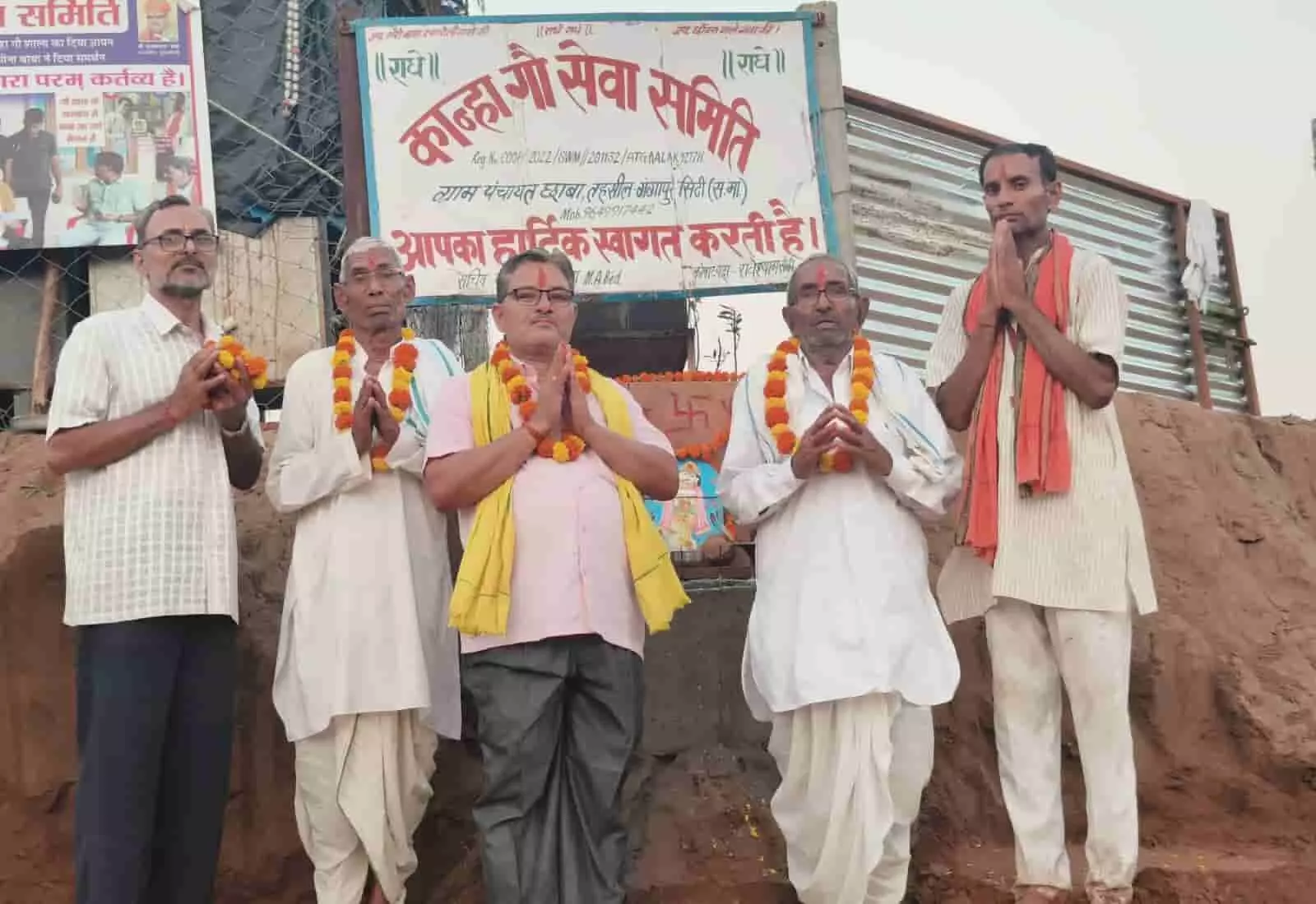 तस्वीर में पांच पुरुष फूलों की माला पहने कान्हा गौ सेवा समिति बोर्ड के सामने प्रार्थना करते दिख रहे हैं। तस्वीर में पांच पुरुष फूलों की माला पहने कान्हा गौ सेवा समिति बोर्ड के सामने प्रार्थना करते दिख रहे हैं।