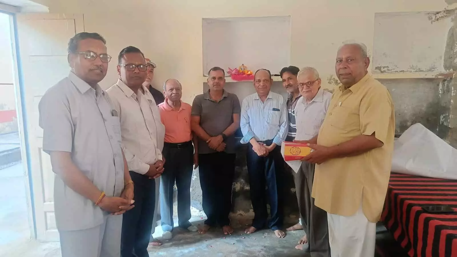 तस्वीर में दिख रही कमरे की दीवार के सामने बाईं से दाईं ओर खड़े अतिथि प्रसादी वितरण कार्यक्रम में शामिल हैं। तस्वीर में दिख रही कमरे की दीवार के सामने बाईं से दाईं ओर खड़े अतिथि प्रसादी वितरण कार्यक्रम में शामिल हैं।