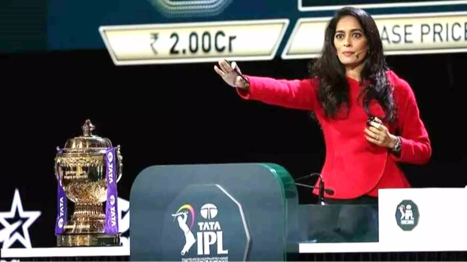 लाल कोट पहने महिला नीलामीकर्ता आईपीएल मंच पर खड़ी हैं और गोवा में होने वाले आगामी मिनी ऑक्शन के संदर्भ में दिख रही हैं। लाल कोट पहने महिला नीलामीकर्ता आईपीएल मंच पर खड़ी हैं और गोवा में होने वाले आगामी मिनी ऑक्शन के संदर्भ में दिख रही हैं।