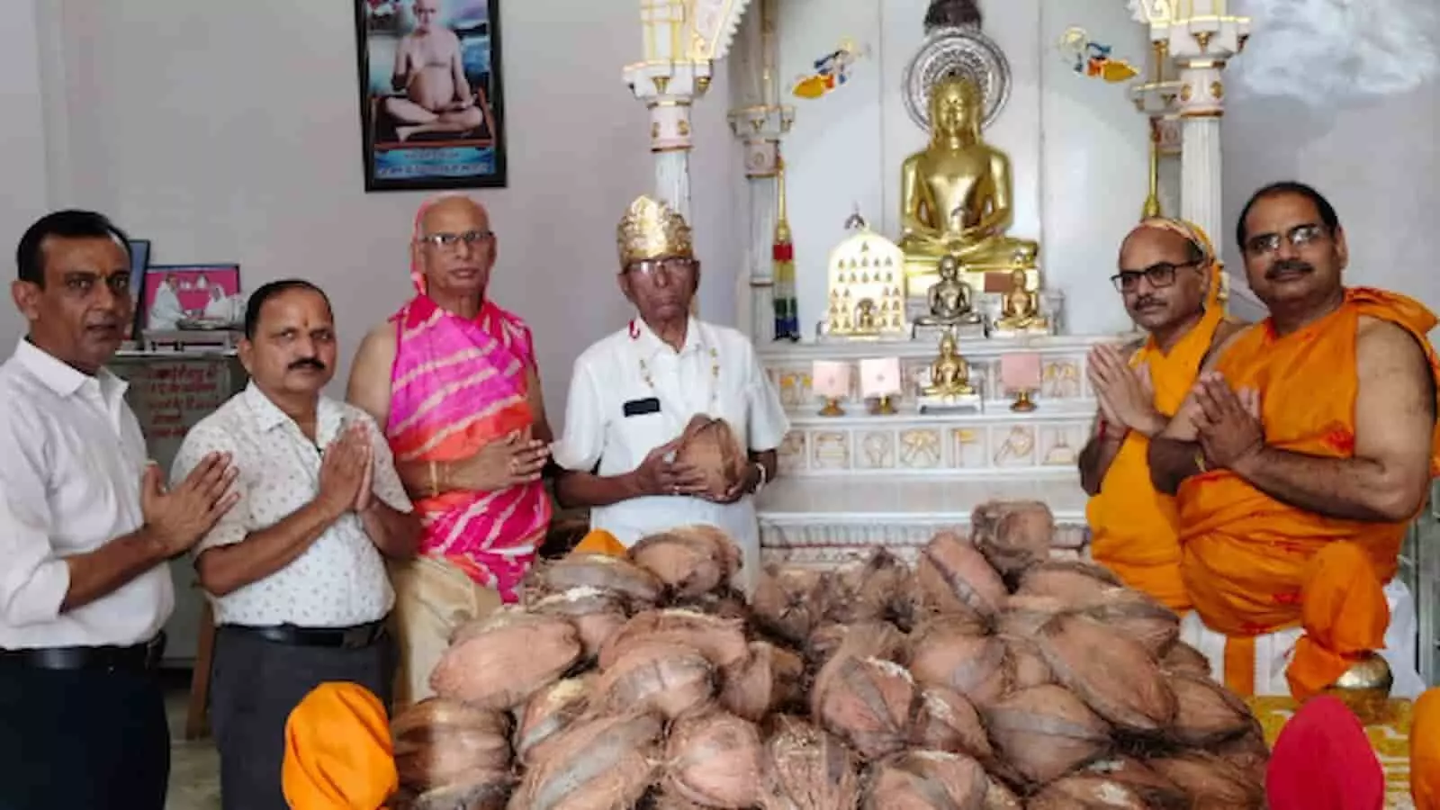 मंदिर में मूर्ति के सामने हाथ जोड़े खड़े श्रद्धालु और सूखे नारियलों का ढेर। मंदिर में मूर्ति के सामने हाथ जोड़े खड़े श्रद्धालु और सूखे नारियलों का ढेर।