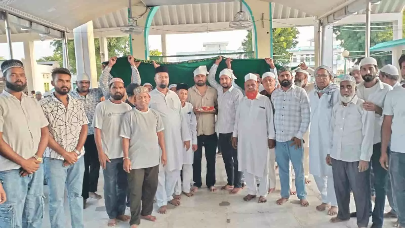 तस्वीर में बाएं से खड़े लोग, केंद्र में चादर पकड़े हुए असरार शेख और अन्य जनप्रतिनिधि दरगाह परिसर में दिखाई दे रहे हैं। तस्वीर में बाएं से खड़े लोग, केंद्र में चादर पकड़े हुए असरार शेख और अन्य जनप्रतिनिधि दरगाह परिसर में दिखाई दे रहे हैं।