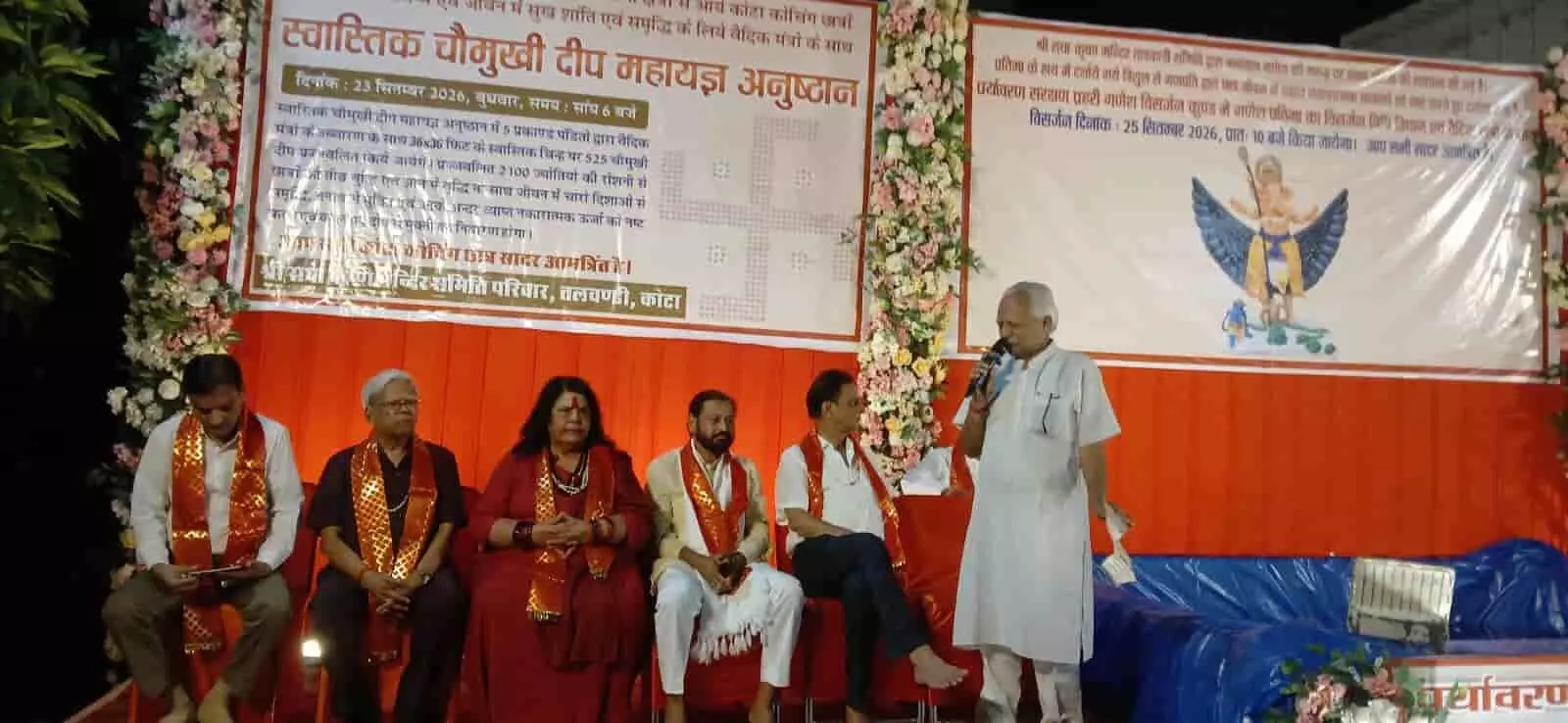 तस्वीर में दिख रही मंच पर एक व्यक्ति हाथ में माइक लेकर सभा को संबोधित कर रहा है। तस्वीर में दिख रही मंच पर एक व्यक्ति हाथ में माइक लेकर सभा को संबोधित कर रहा है।