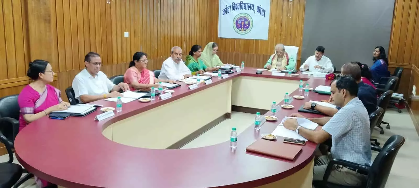 तस्वीर में कोटा विश्वविद्यालय के प्रशासनिक भवन में मेज के चारों ओर बैठे प्रबंध मंडल के सदस्य। तस्वीर में कोटा विश्वविद्यालय के प्रशासनिक भवन में मेज के चारों ओर बैठे प्रबंध मंडल के सदस्य।