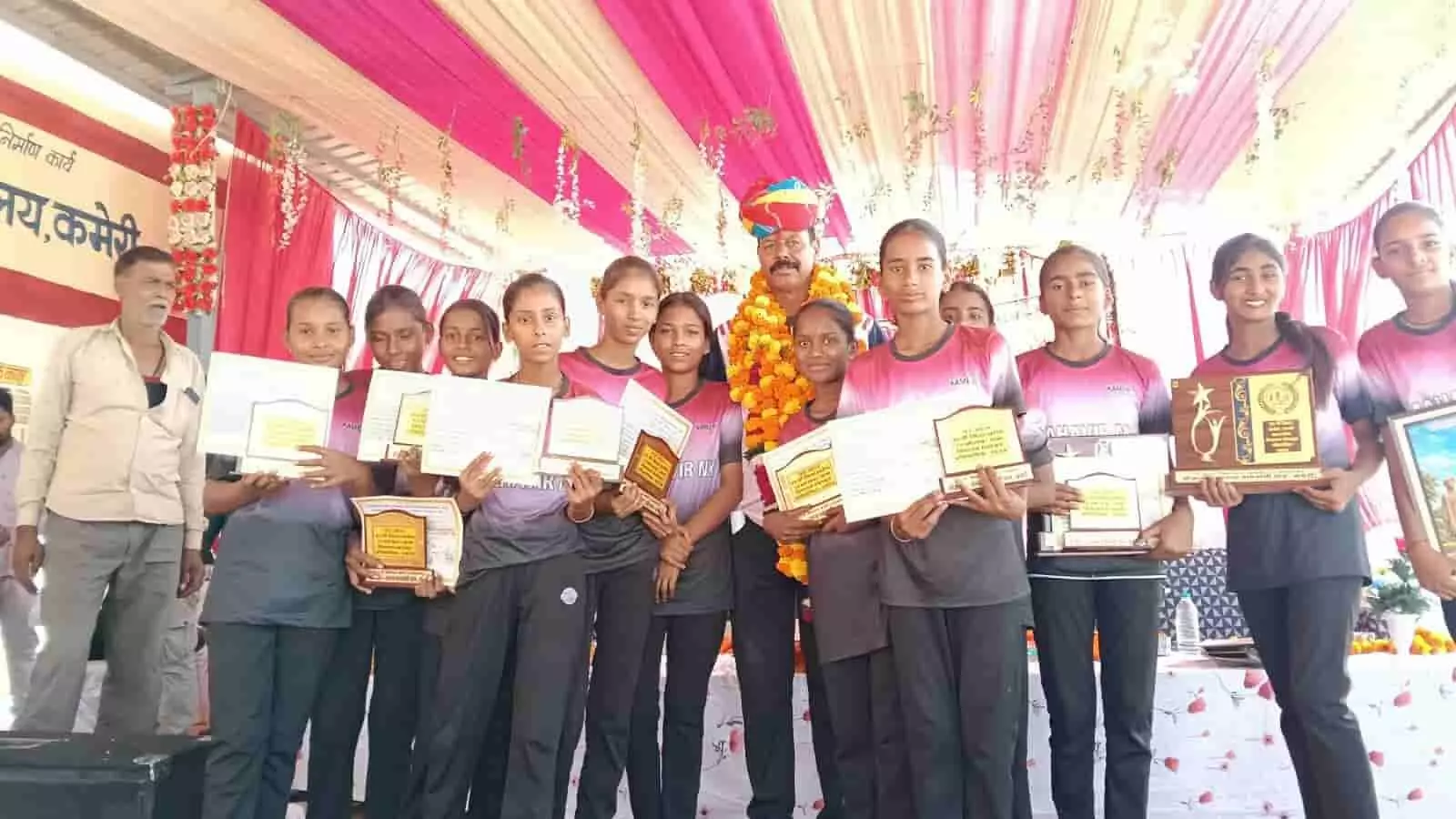तस्वीर में विजेता छात्राएं और शिक्षक कमेरी में नेटबॉल प्रतियोगिता की ट्रॉफियों के साथ दिख रहे हैं। तस्वीर में विजेता छात्राएं और शिक्षक कमेरी में नेटबॉल प्रतियोगिता की ट्रॉफियों के साथ दिख रहे हैं।