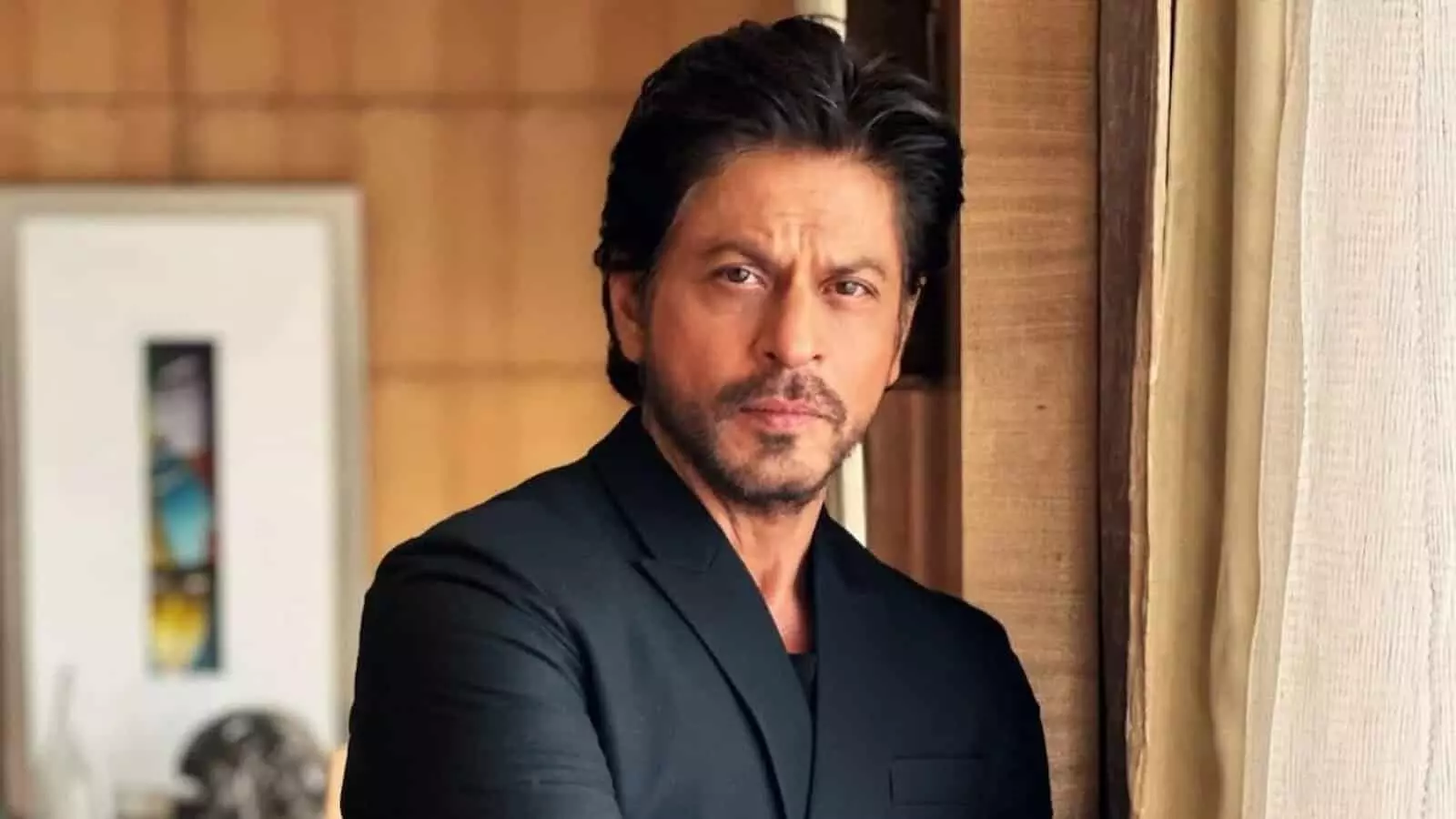 तस्वीर में काले कपड़ों में अभिनेता शाहरुख खान एक कमरे के अंदर खड़े दिख रहे हैं। तस्वीर में काले कपड़ों में अभिनेता शाहरुख खान एक कमरे के अंदर खड़े दिख रहे हैं।