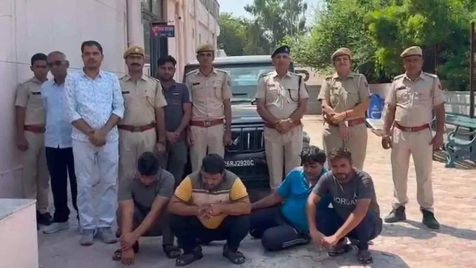 पुलिसकर्मी थाने के बाहर गिरफ्तार चार आरोपियों और जब्त गाड़ी के पास खड़े हैं। पुलिसकर्मी थाने के बाहर गिरफ्तार चार आरोपियों और जब्त गाड़ी के पास खड़े हैं।