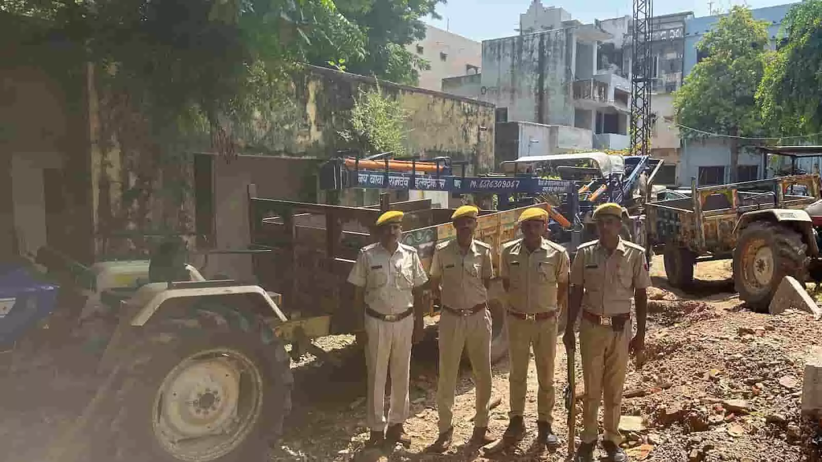 तस्वीर में चार पुलिसकर्मी जब्त किए गए ट्रैक्टरों के आगे कतार में खड़े हैं। तस्वीर में चार पुलिसकर्मी जब्त किए गए ट्रैक्टरों के आगे कतार में खड़े हैं।