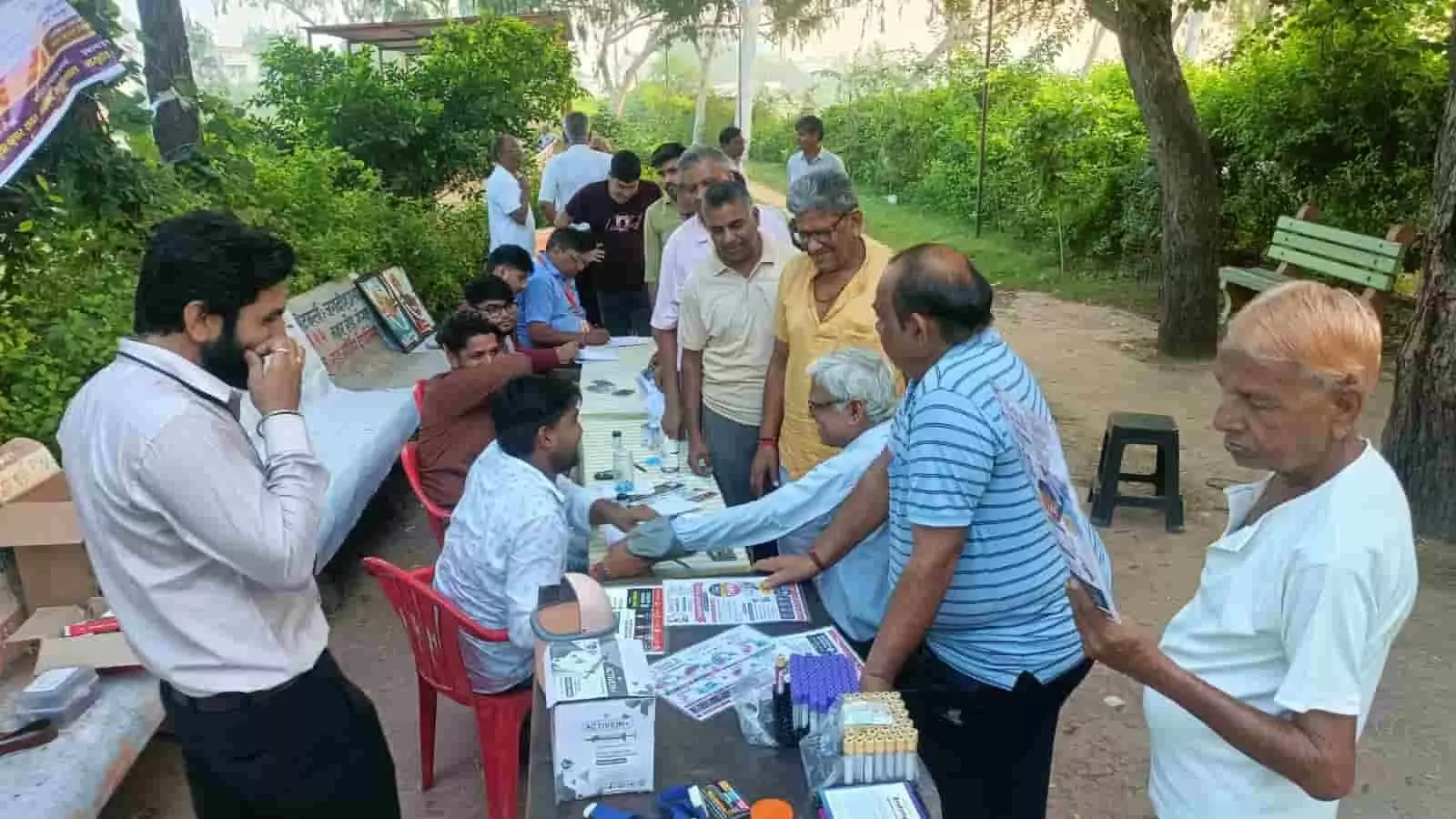तस्वीर में स्वास्थ्य जांच शिविर के दौरान टेबल पर स्वास्थ्य कर्मी व्यक्ति का ब्लड प्रेशर माप रहे हैं। तस्वीर में स्वास्थ्य जांच शिविर के दौरान टेबल पर स्वास्थ्य कर्मी व्यक्ति का ब्लड प्रेशर माप रहे हैं।