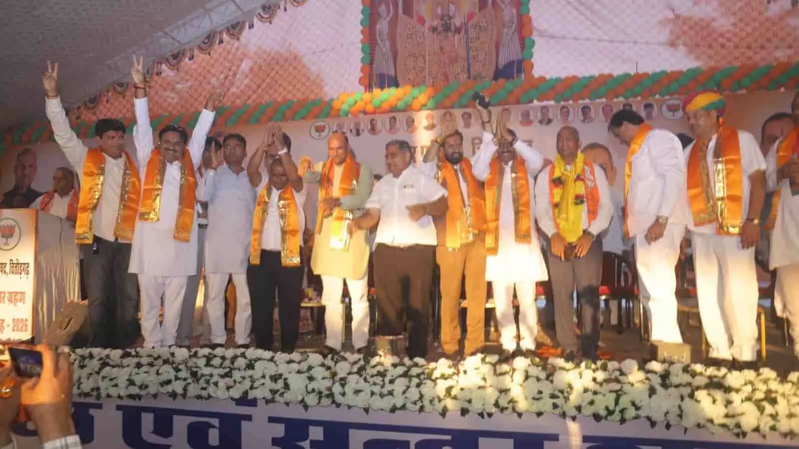 तस्वीर में दिख रही एक मंच की घटना, जहां भगवा दुपट्टा पहने जनप्रतिनिधि और भाजपा पदाधिकारी हाथ उठाकर जनता का अभिवादन कर रहे हैं। तस्वीर में दिख रही एक मंच की घटना, जहां भगवा दुपट्टा पहने जनप्रतिनिधि और भाजपा पदाधिकारी हाथ उठाकर जनता का अभिवादन कर रहे हैं।