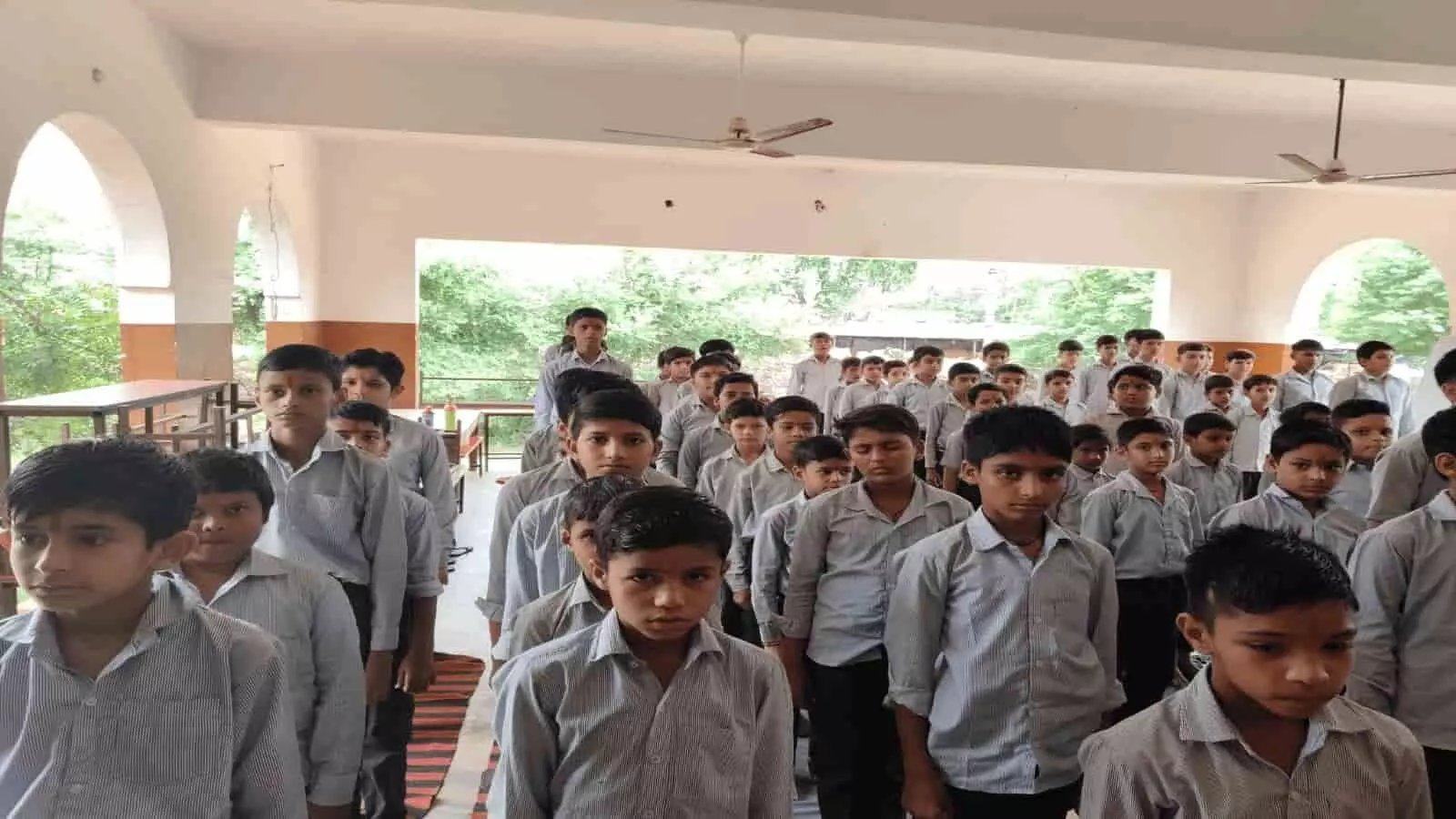 तस्वीर में स्कूल की पोशाक पहने हुए विद्यार्थियों का समूह पंक्तिबद्ध होकर खड़े हुए दिखाई दे रहा है। तस्वीर में स्कूल की पोशाक पहने हुए विद्यार्थियों का समूह पंक्तिबद्ध होकर खड़े हुए दिखाई दे रहा है।