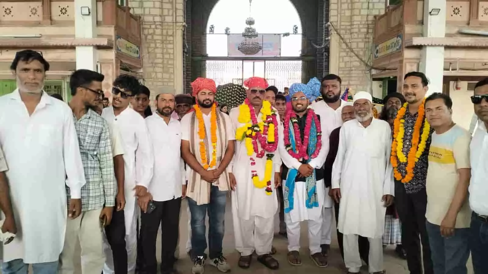 तस्वीर में माला पहने हुए नवनिर्वाचित पार्षदों और उनके समर्थकों का समूह दरगाह के द्वार के सामने खड़ा दिखाई दे रहा है। तस्वीर में माला पहने हुए नवनिर्वाचित पार्षदों और उनके समर्थकों का समूह दरगाह के द्वार के सामने खड़ा दिखाई दे रहा है।