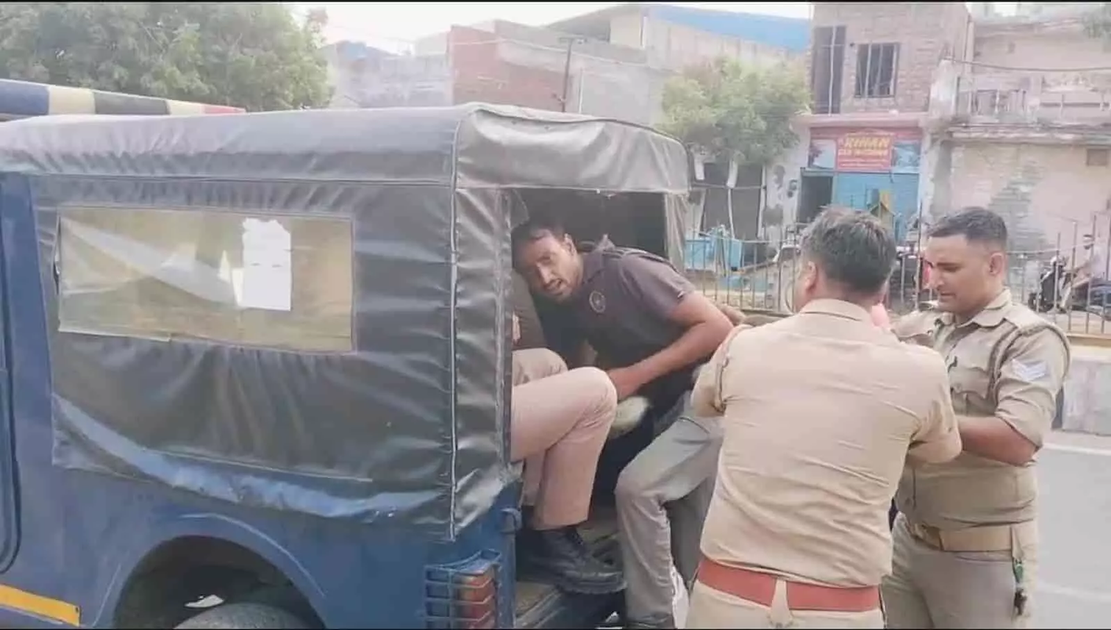 हापुड़ में पुलिस की गाड़ी के पास खड़े पुलिसकर्मी संदिग्ध आरोपी को गाड़ी में चढ़ाते हुए। हापुड़ में पुलिस की गाड़ी के पास खड़े पुलिसकर्मी संदिग्ध आरोपी को गाड़ी में चढ़ाते हुए।
