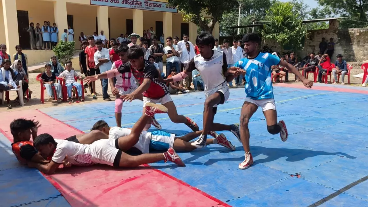 तस्वीर में नीले और सफेद जर्सी पहने कबड्डी खिलाड़ी मैदान पर रेड करते और दांव-पेच लगाते नजर आ रहे हैं। तस्वीर में नीले और सफेद जर्सी पहने कबड्डी खिलाड़ी मैदान पर रेड करते और दांव-पेच लगाते नजर आ रहे हैं।