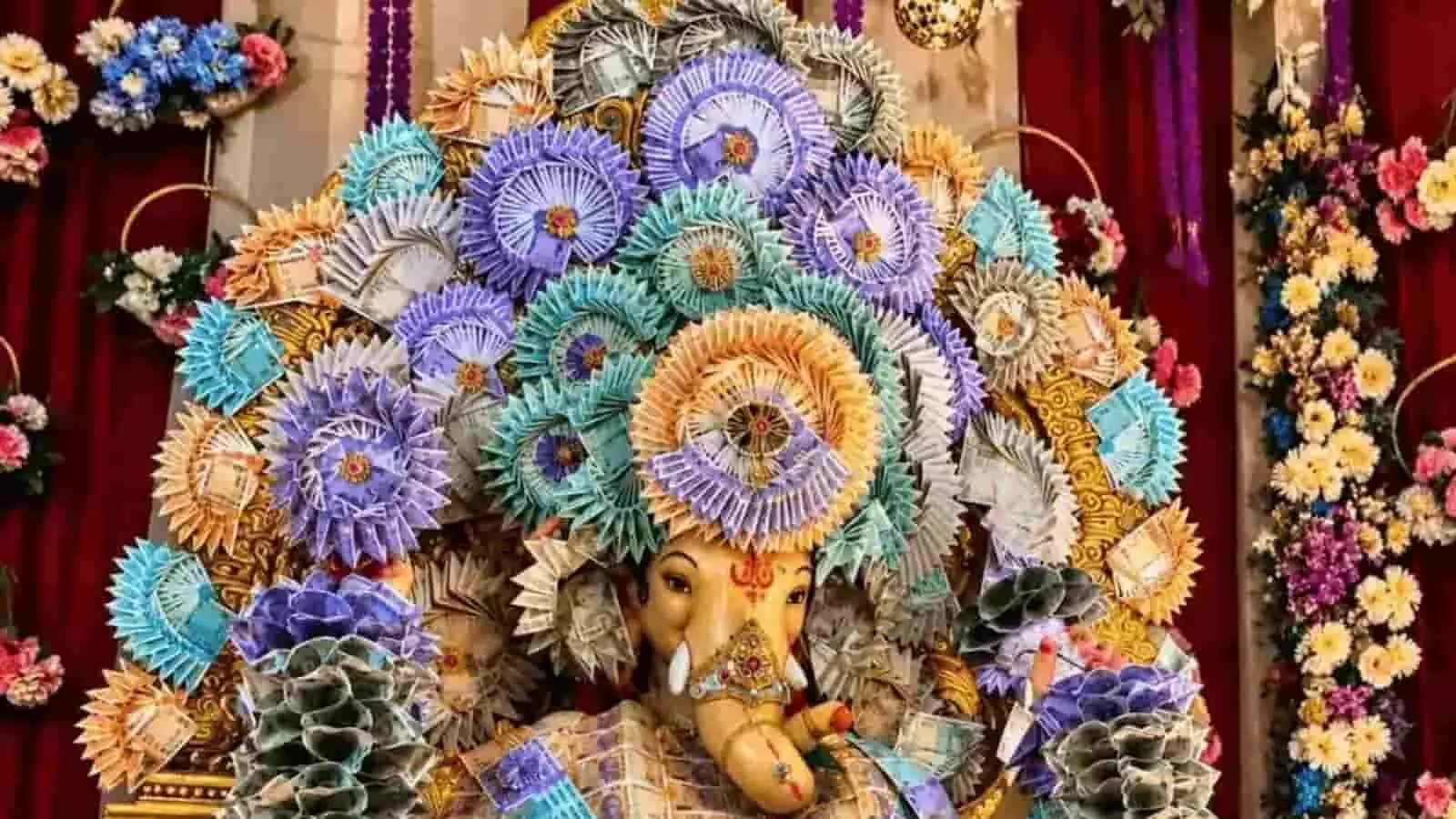 तस्वीर में फूलों और नोटों की सजावट के बीच भगवान गणेश की भव्य झांकी नजर आ रही है। तस्वीर में फूलों और नोटों की सजावट के बीच भगवान गणेश की भव्य झांकी नजर आ रही है।