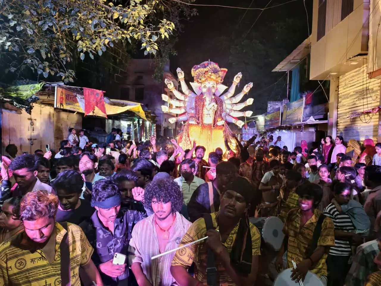 तस्वीर में सड़क पर बड़ी संख्या में मौजूद भीड़ और जगमगाती गणेश प्रतिमा के साथ विसर्जन यात्रा नजर आ रही है। तस्वीर में सड़क पर बड़ी संख्या में मौजूद भीड़ और जगमगाती गणेश प्रतिमा के साथ विसर्जन यात्रा नजर आ रही है।