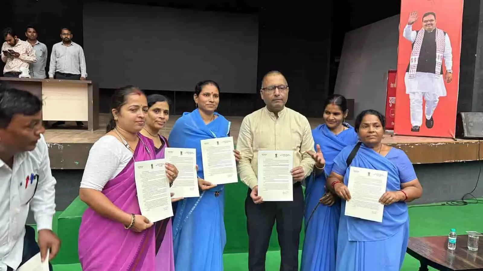 सभागार में प्रशस्ति पत्र हाथ में लेकर खड़े अधिकारी और सम्मानित आशा सहयोगिनियां। सभागार में प्रशस्ति पत्र हाथ में लेकर खड़े अधिकारी और सम्मानित आशा सहयोगिनियां।
