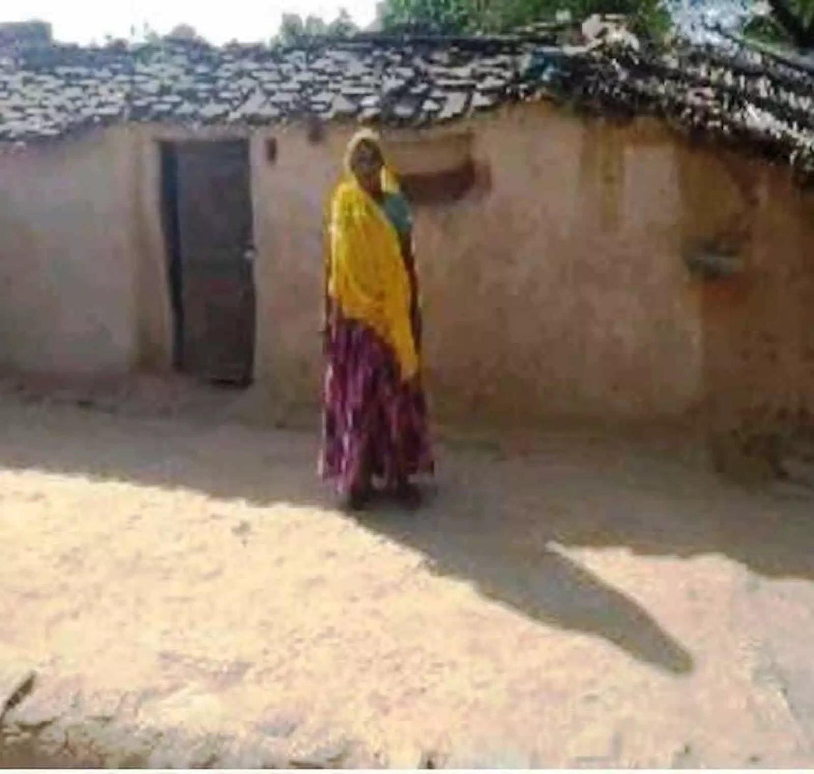 सवाई माधोपुर के फुलवाड़ा में कच्चे मिट्टी के मकान के सामने खड़ी एक महिला। सवाई माधोपुर के फुलवाड़ा में कच्चे मिट्टी के मकान के सामने खड़ी एक महिला।