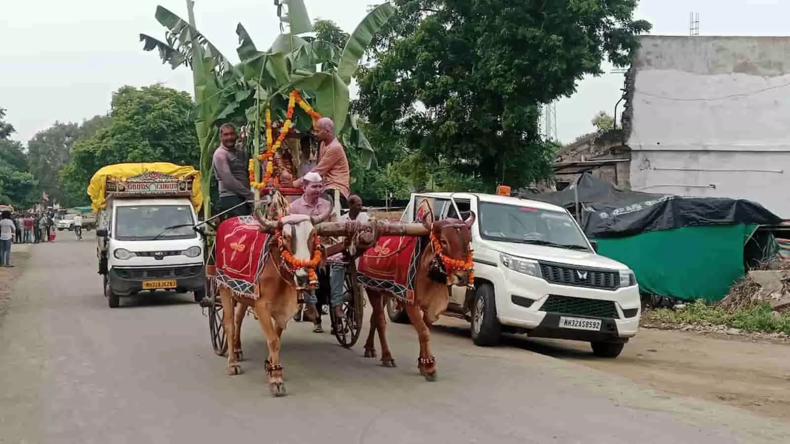 तस्वीर में आगे बैलगाड़ी पर सजे बप्पा और पीछे पुलिस की गाड़ी तथा लोग दिखाई दे रहे हैं। तस्वीर में आगे बैलगाड़ी पर सजे बप्पा और पीछे पुलिस की गाड़ी तथा लोग दिखाई दे रहे हैं।