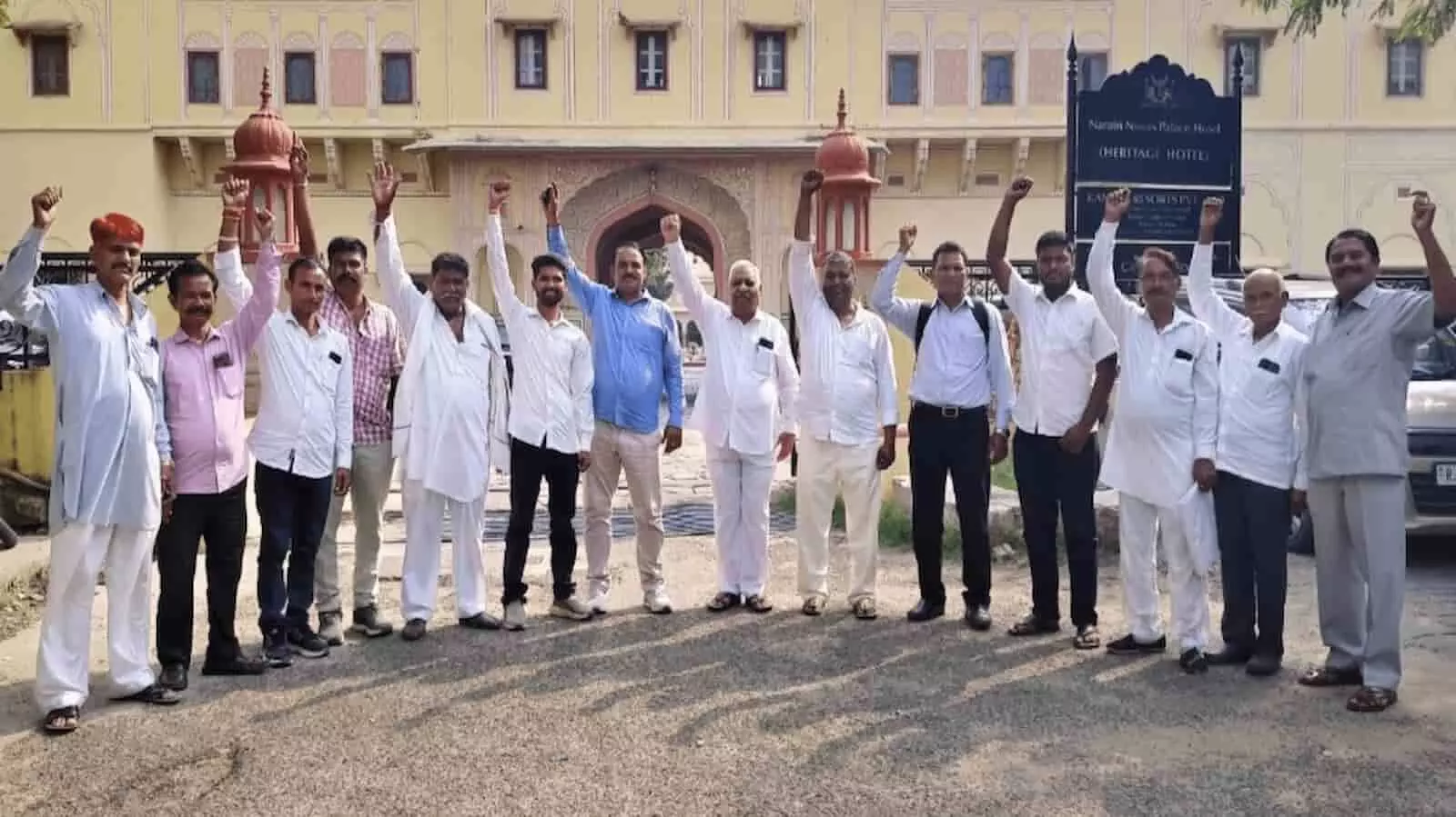 तस्वीर में खुले आसमान के नीचे हाथ उठाकर नारेबाजी करते हुए खड़े कई पुरुष दिखाई दे रहे हैं। तस्वीर में खुले आसमान के नीचे हाथ उठाकर नारेबाजी करते हुए खड़े कई पुरुष दिखाई दे रहे हैं।