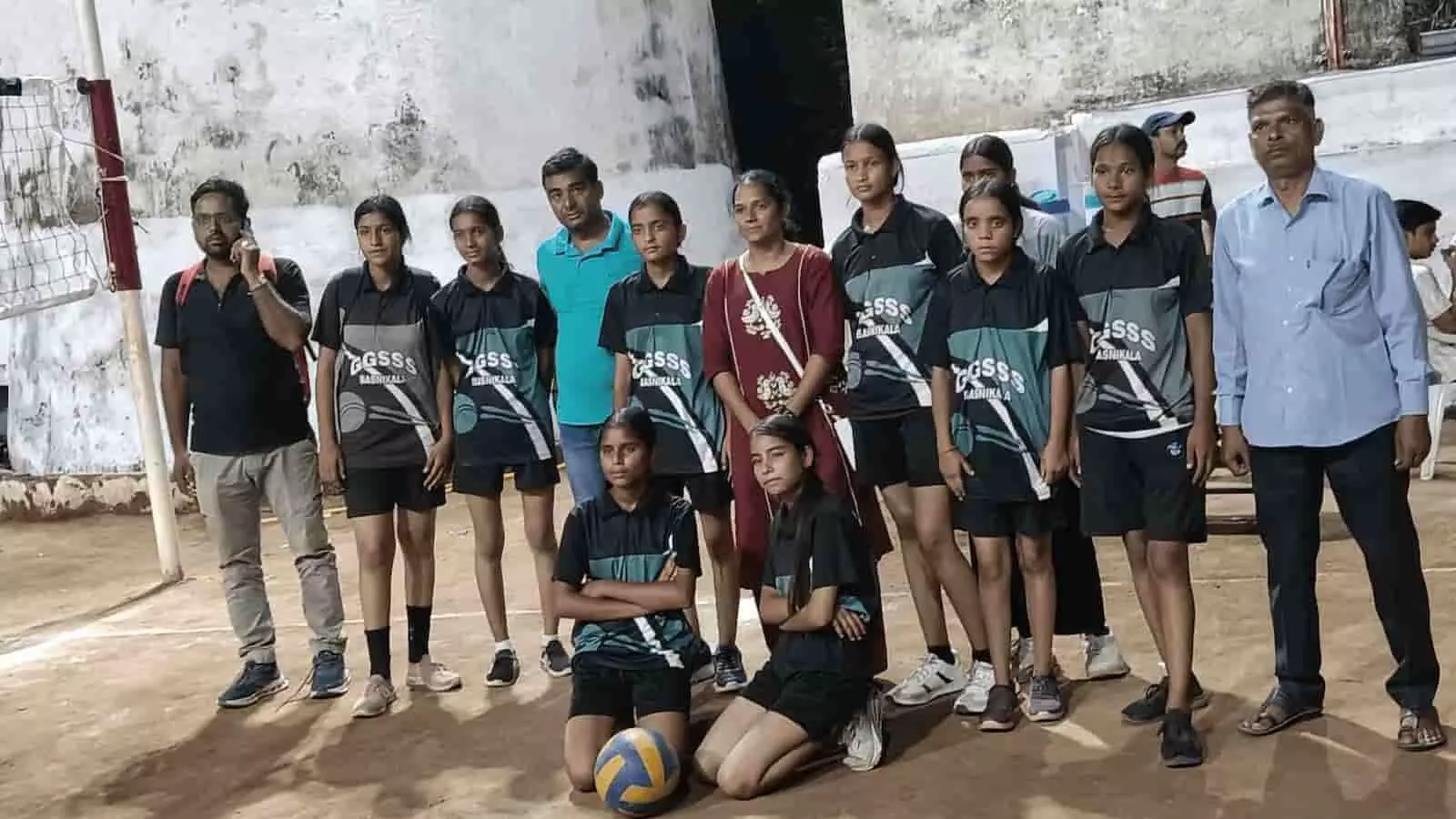 तस्वीर में खेल मैदान पर वॉलीबॉल के साथ खड़ी स्कूली छात्राएं और उनके शिक्षक दिखाई दे रहे हैं। तस्वीर में खेल मैदान पर वॉलीबॉल के साथ खड़ी स्कूली छात्राएं और उनके शिक्षक दिखाई दे रहे हैं।