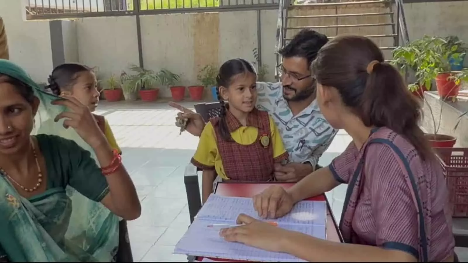 तस्वीर में स्कूल प्रांगण में शिक्षक, अभिभावक और विद्यार्थी बातचीत करते हुए दिखाई दे रहे हैं। तस्वीर में स्कूल प्रांगण में शिक्षक, अभिभावक और विद्यार्थी बातचीत करते हुए दिखाई दे रहे हैं।