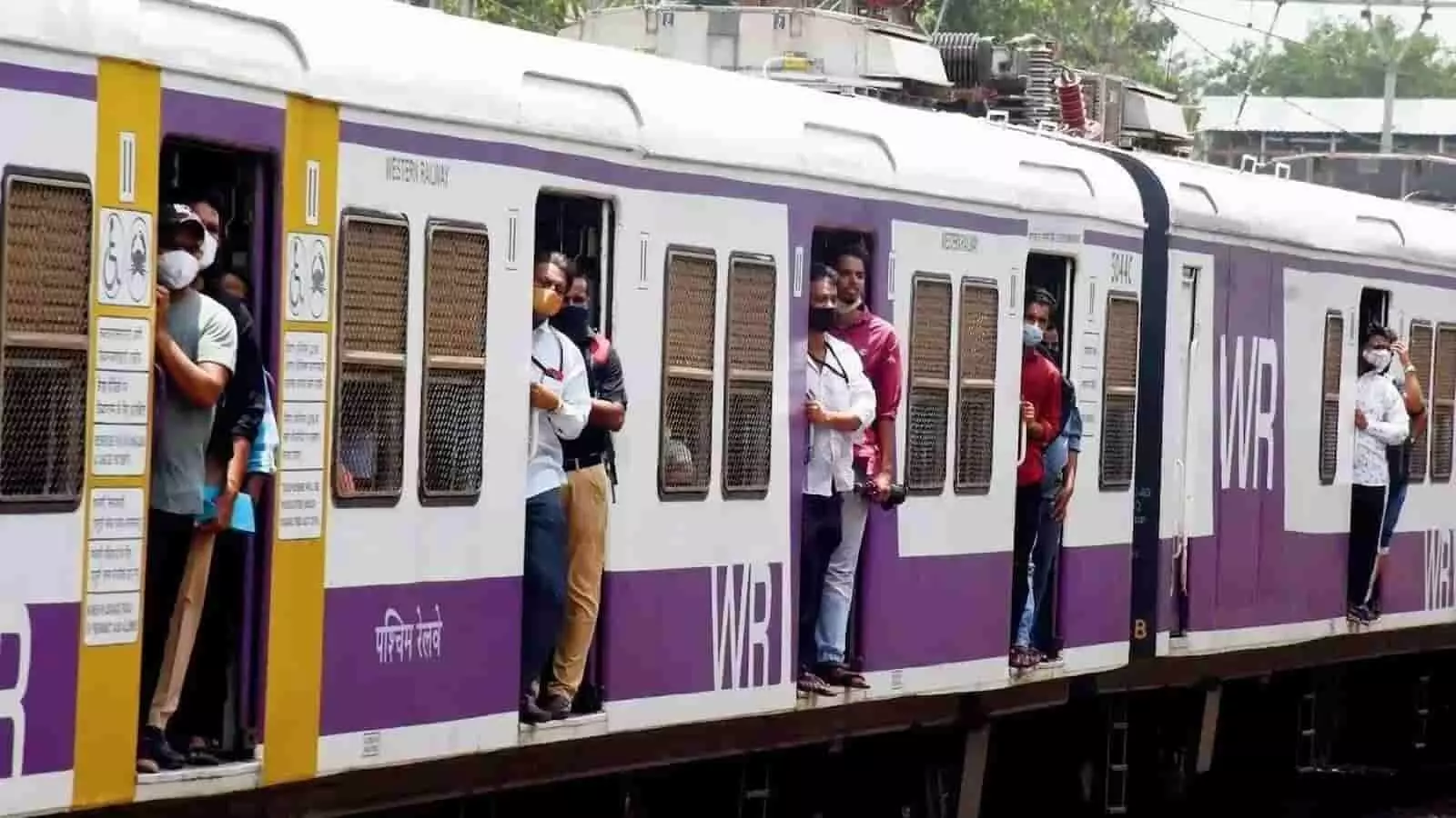 तस्वीर में मुंबई लोकल ट्रेन के दरवाजों पर खड़े यात्री दिखाई दे रहे हैं। तस्वीर में मुंबई लोकल ट्रेन के दरवाजों पर खड़े यात्री दिखाई दे रहे हैं।