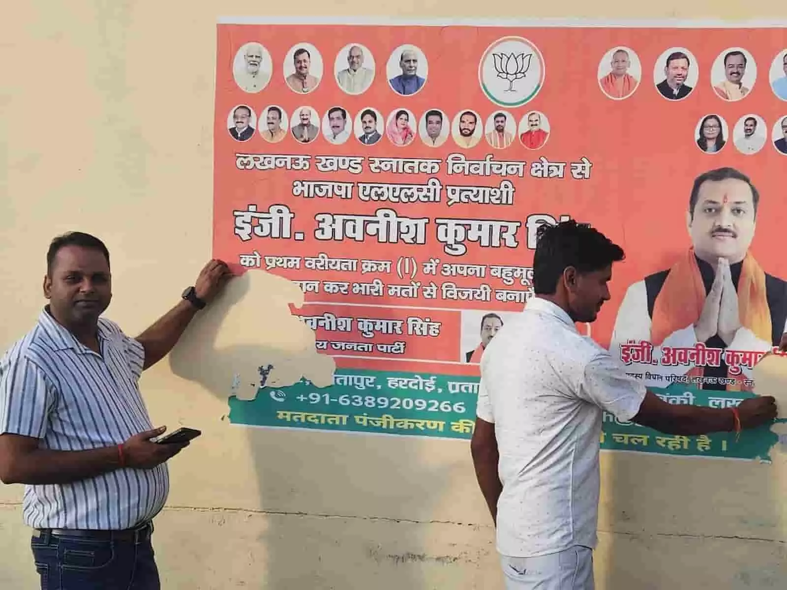 दीवार पर लगे राजनीतिक पोस्टर को हाथ से उखाड़कर हटाते कर्मचारी। दीवार पर लगे राजनीतिक पोस्टर को हाथ से उखाड़कर हटाते कर्मचारी।