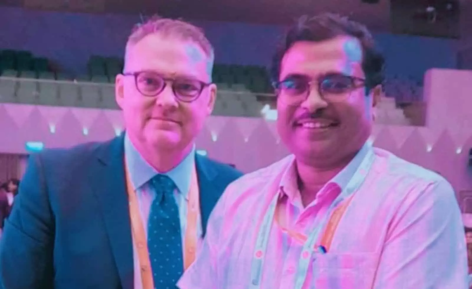 तस्वीर में बाएं माइक लउंड्री और दाएं डॉ. रत्नेश चौधरी सम्मेलन के दौरान मुस्कुराते हुए खड़े हैं। तस्वीर में बाएं माइक लउंड्री और दाएं डॉ. रत्नेश चौधरी सम्मेलन के दौरान मुस्कुराते हुए खड़े हैं।
