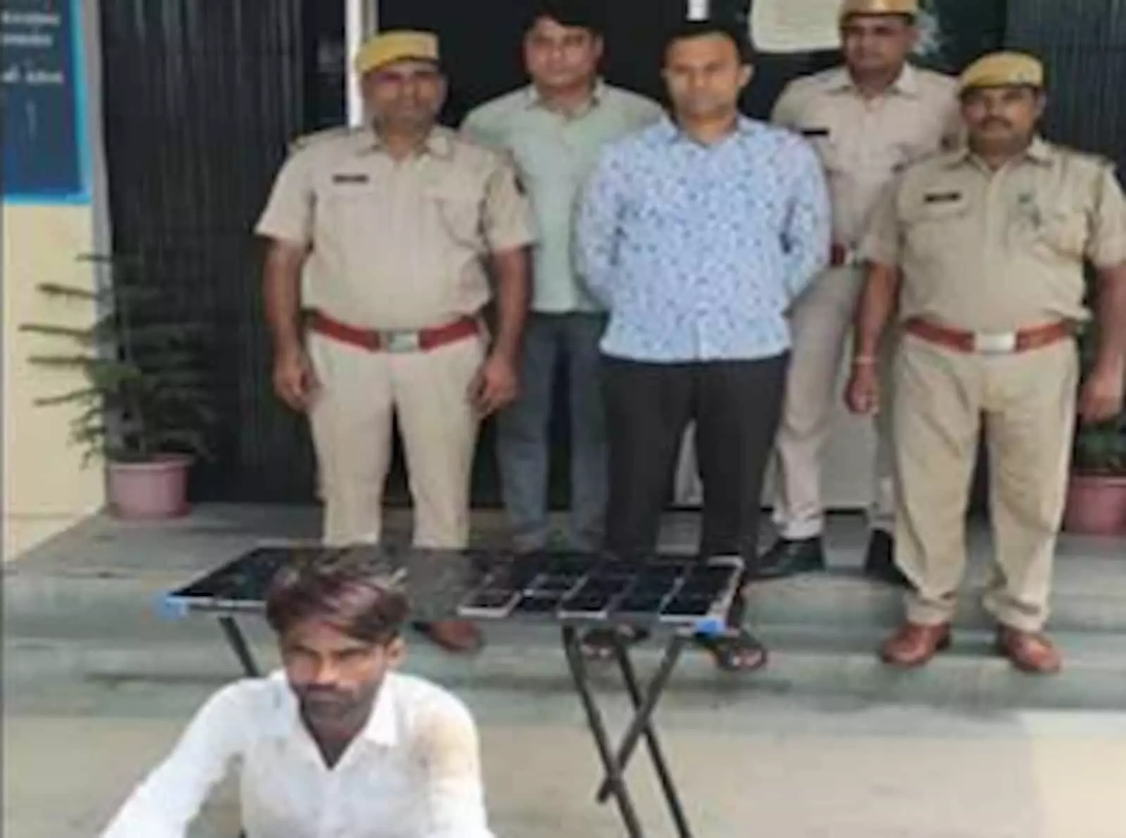 तस्वीर में पुलिसकर्मियों के साथ खड़ा गिरफ्तार आरोपी और सामने रखे चोरी के मोबाइल फोन दिख रहे हैं। तस्वीर में पुलिसकर्मियों के साथ खड़ा गिरफ्तार आरोपी और सामने रखे चोरी के मोबाइल फोन दिख रहे हैं।