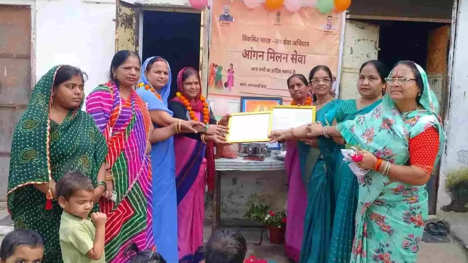 सवाई माधोपुर के आंगनबाड़ी केंद्र में बैनर के सामने प्रशस्ति पत्र प्राप्त करती महिलाएं। सवाई माधोपुर के आंगनबाड़ी केंद्र में बैनर के सामने प्रशस्ति पत्र प्राप्त करती महिलाएं।