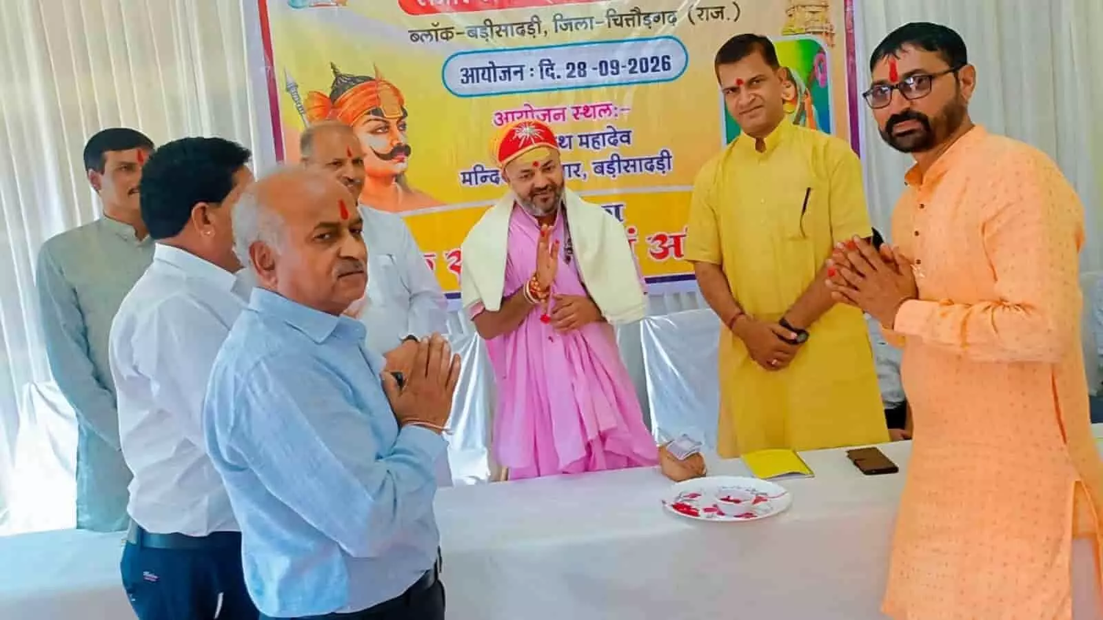 सभागार में बैनर के सामने हाथ जोड़कर अतिथियों का अभिनंदन करते आयोजक और गणमान्य व्यक्ति। सभागार में बैनर के सामने हाथ जोड़कर अतिथियों का अभिनंदन करते आयोजक और गणमान्य व्यक्ति।