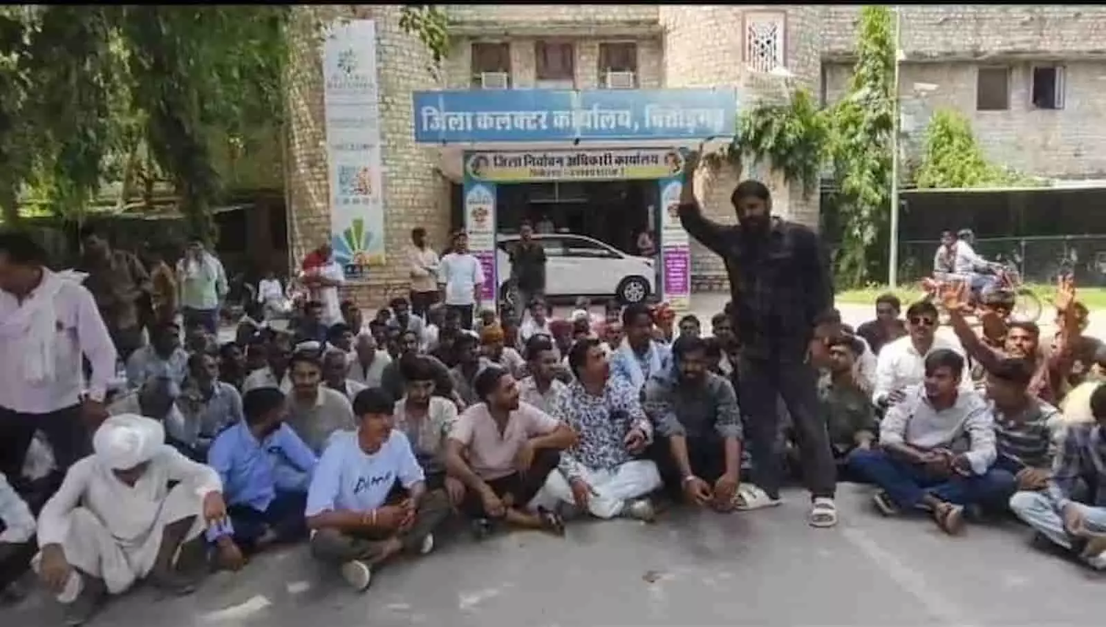 चित्तौड़गढ़ कलेक्ट्रेट कार्यालय परिसर के बाहर हाथ उठाकर विरोध जताते और धरने पर बैठे पारोली गांव के लोग। चित्तौड़गढ़ कलेक्ट्रेट कार्यालय परिसर के बाहर हाथ उठाकर विरोध जताते और धरने पर बैठे पारोली गांव के लोग।