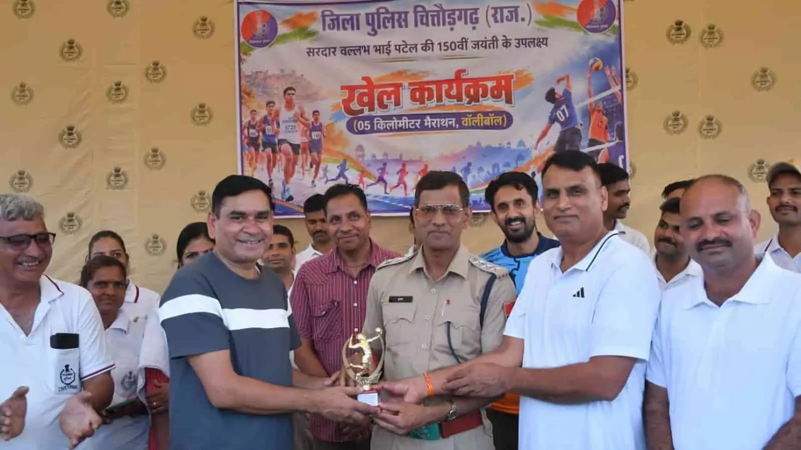 तस्वीर में बाएं से दाएं खड़े प्रतिभागी और वर्दीधारी पुलिस अधिकारी बैनर के आगे विजेता टीम को ट्रॉफी देते दिख रहे हैं। तस्वीर में बाएं से दाएं खड़े प्रतिभागी और वर्दीधारी पुलिस अधिकारी बैनर के आगे विजेता टीम को ट्रॉफी देते दिख रहे हैं।